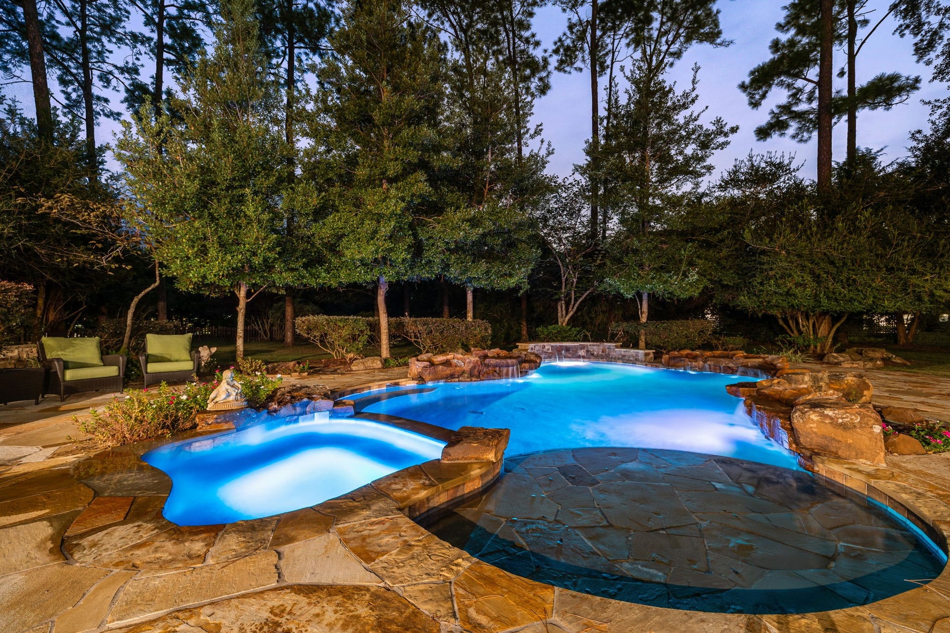 2127 Fawn Meadow Lane, Richmond, TX 77406 Gorgeous backyard retreat featuring a sparkling pool and spa with beach entry and surrounded by lush greenery.