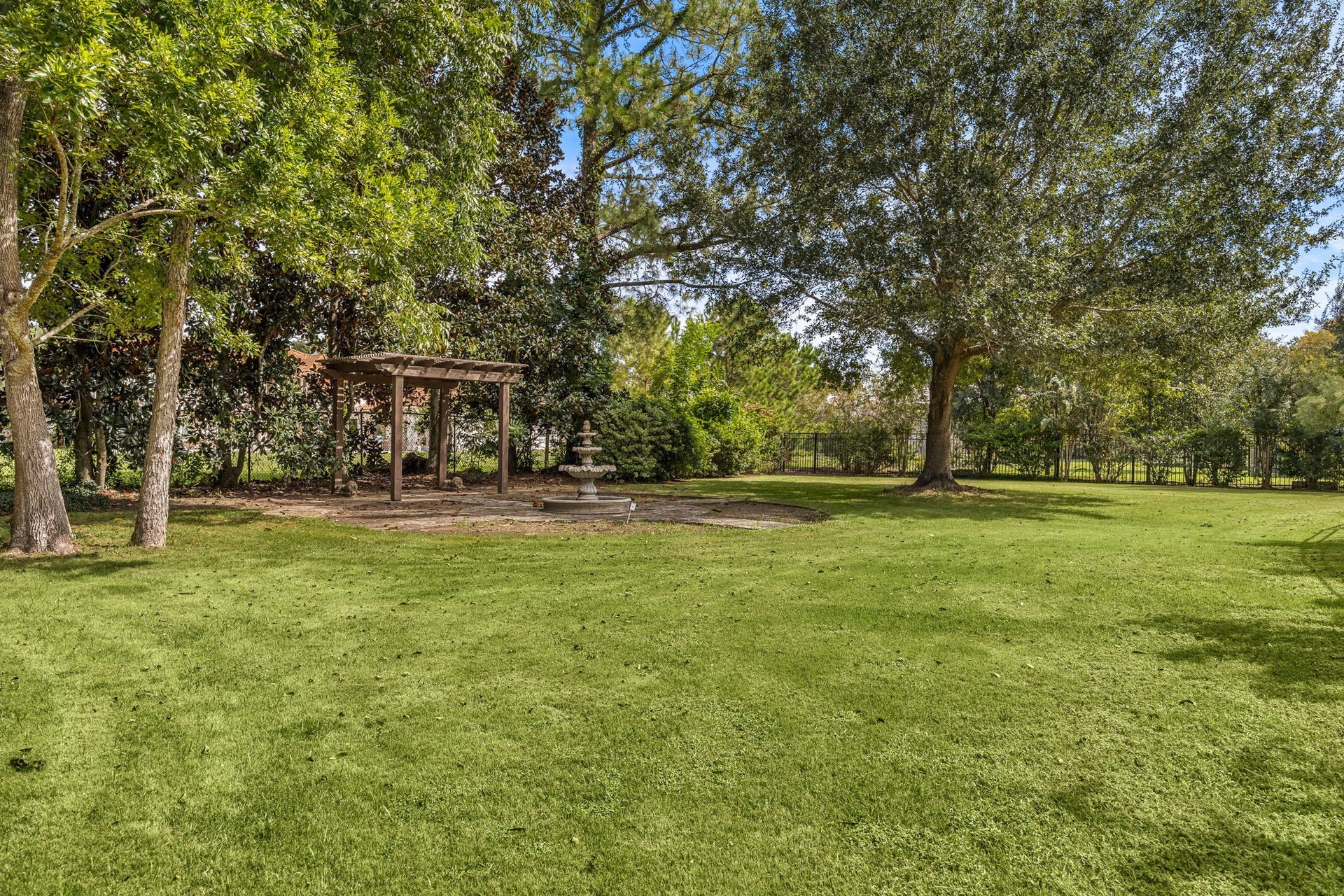 2127 Fawn Meadow Lane, Richmond, TX 77406 Expansive side yard surrounded by mature trees to create additional privacy and beautiful landscaping with water feature.