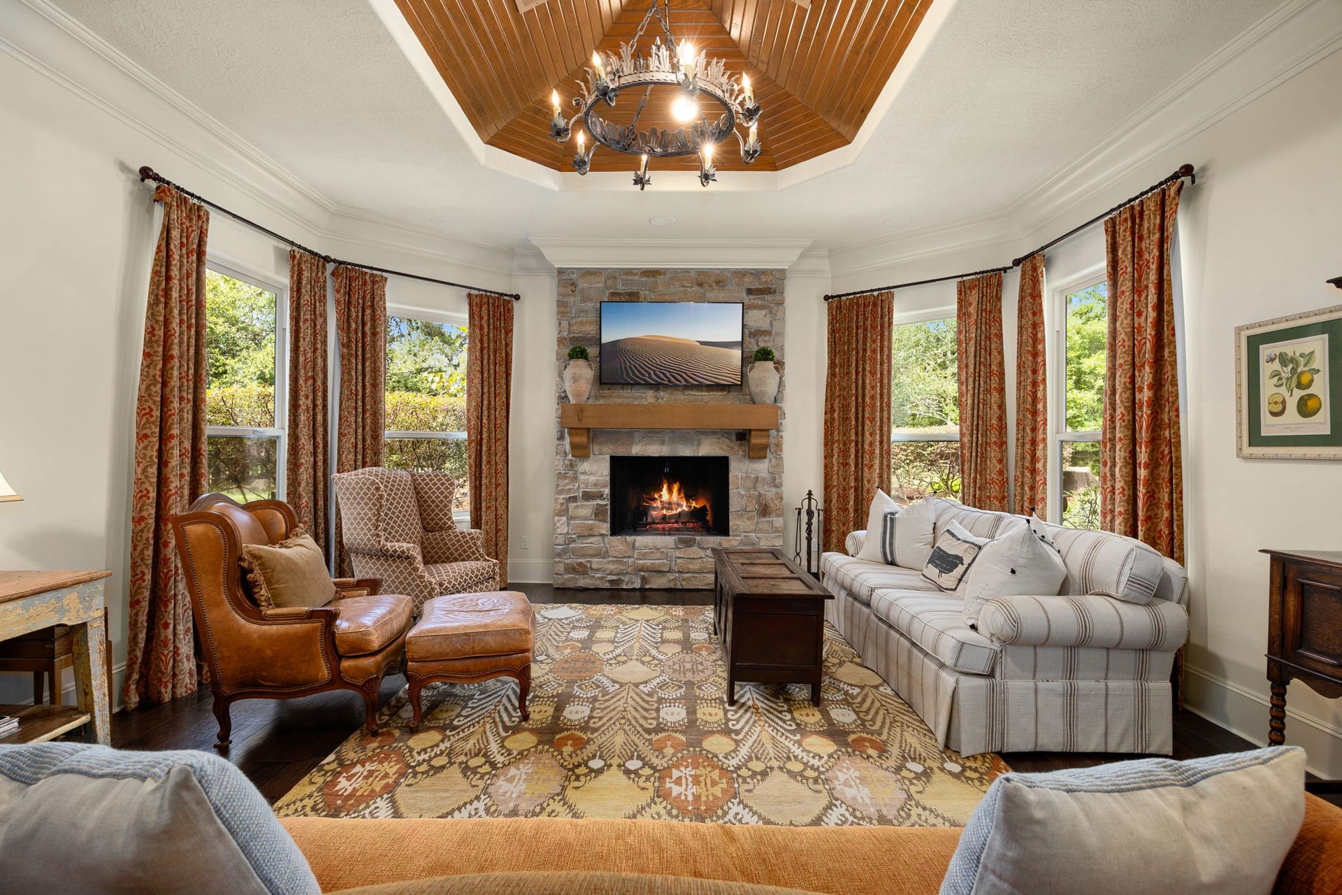 2127 Fawn Meadow Lane, Richmond, TX 77406 Inviting living area with a beautiful stone fireplace and wood mantle, exposed wood ceiling, crown molding, and elegant finishes.