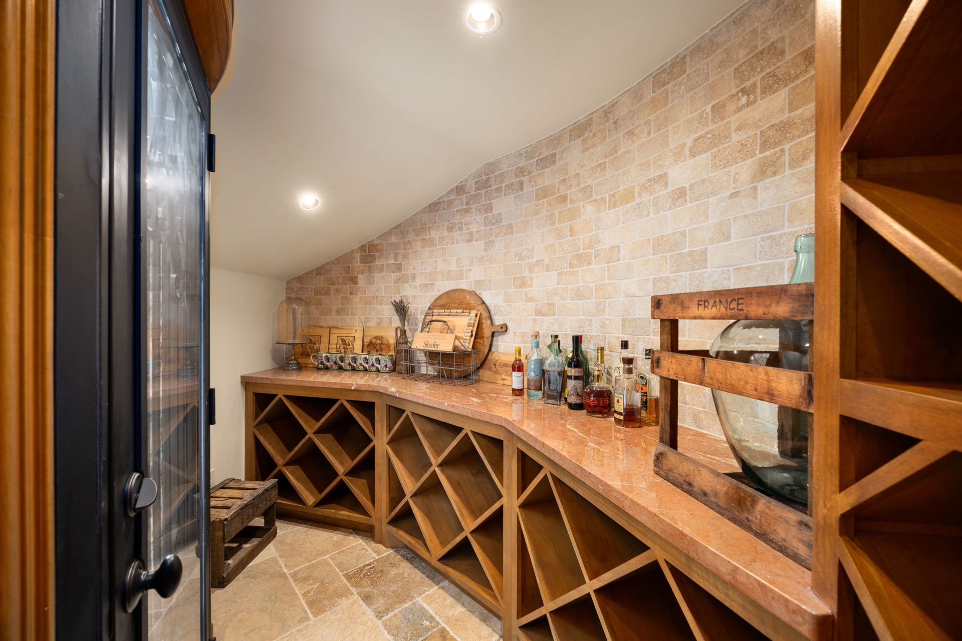2127 Fawn Meadow Lane, Richmond, TX 77406 Custom temperature controlled wine and spirits storage area with built-in wood racks, counter space, and brick accents.