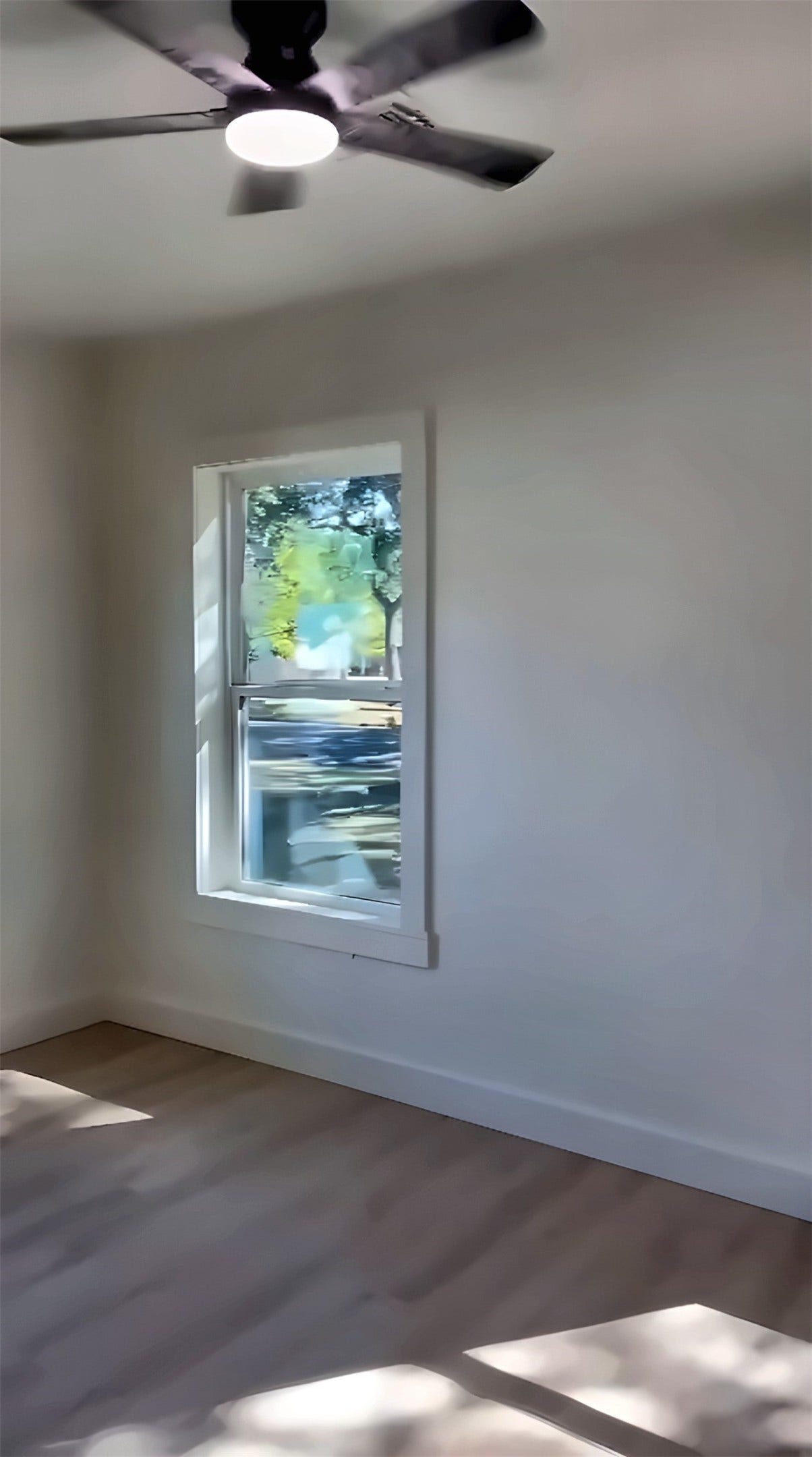 Room with ceiling fan and window with view of yard