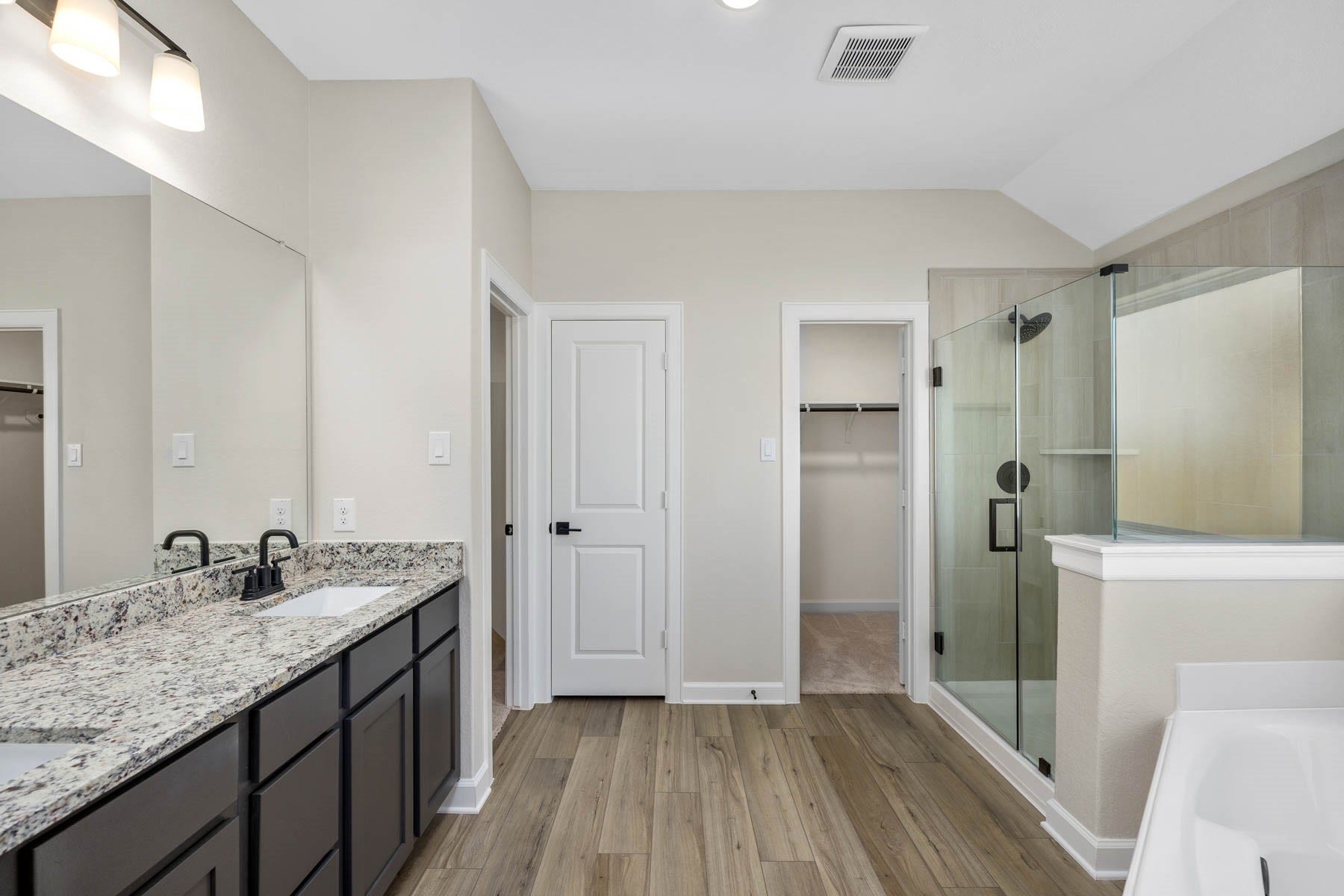 2921 Fair Wind Lane, Texas City, TX 77510 Indulge in luxury with this stunning primary bathroom featuring a spacious corner tub, a grand walk-in shower, and a sleek double sink vanity. Your personal oasis awaits!