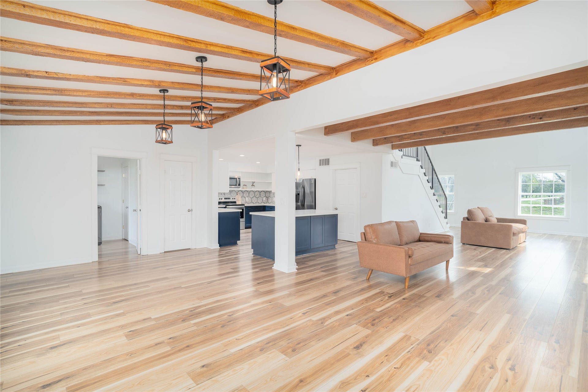 1635 Pony Lane, Wallis, TX 77485 Open Living Area Wide-open living and dining spaces with exposed beams, large windows, and seamless flow ideal for entertaining.