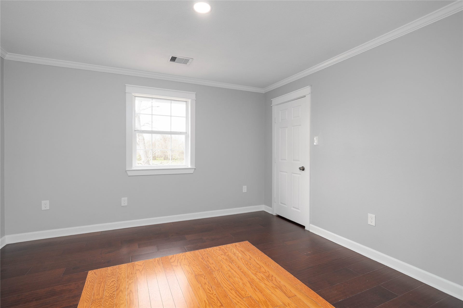 1635 Pony Lane, Wallis, TX 77485 Bedroom Comfortable secondary bedroom with dark wood flooring, neutral tones, and a large window providing natural light. Includes walk-in closet.