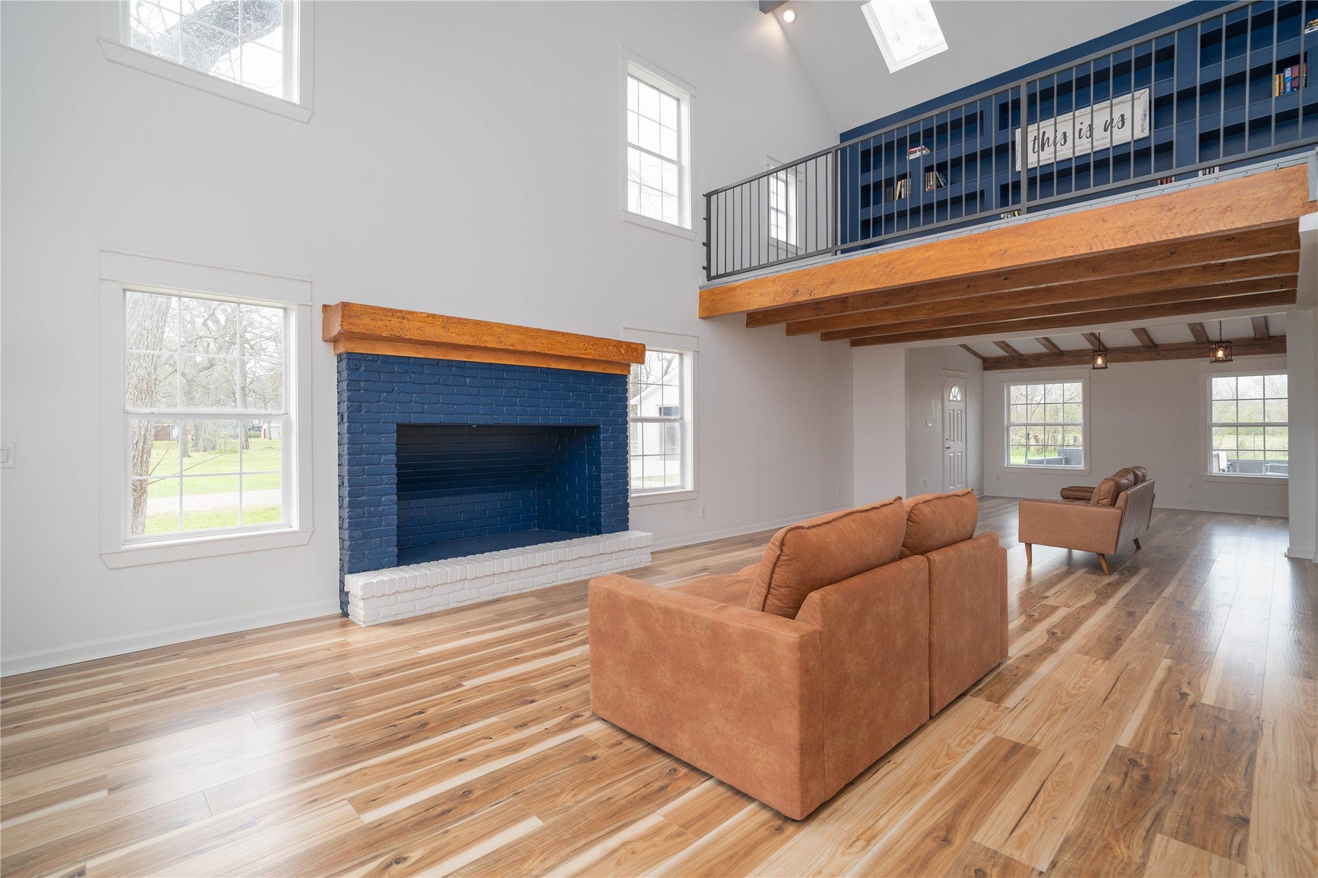 1635 Pony Lane, Wallis, TX 77485 Living Room Spacious living area anchored by a bold painted brick fireplace, framed by large windows that fill the space with natural light.