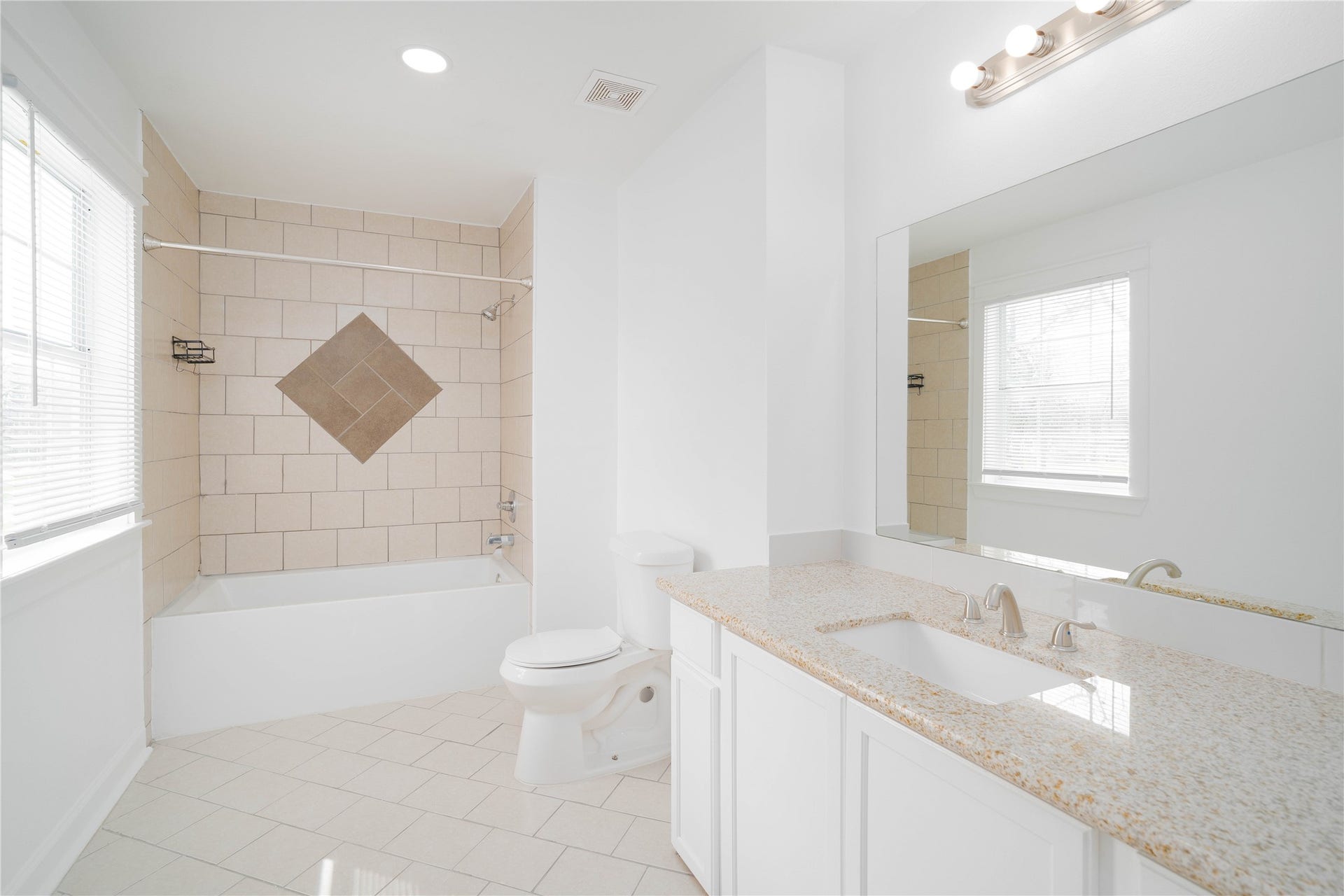 1635 Pony Lane, Wallis, TX 77485 En-suite Bathroom Well-appointed bathroom with a granite-topped vanity, large mirror, and a tiled tub/shower combination accented with decorative inlay.