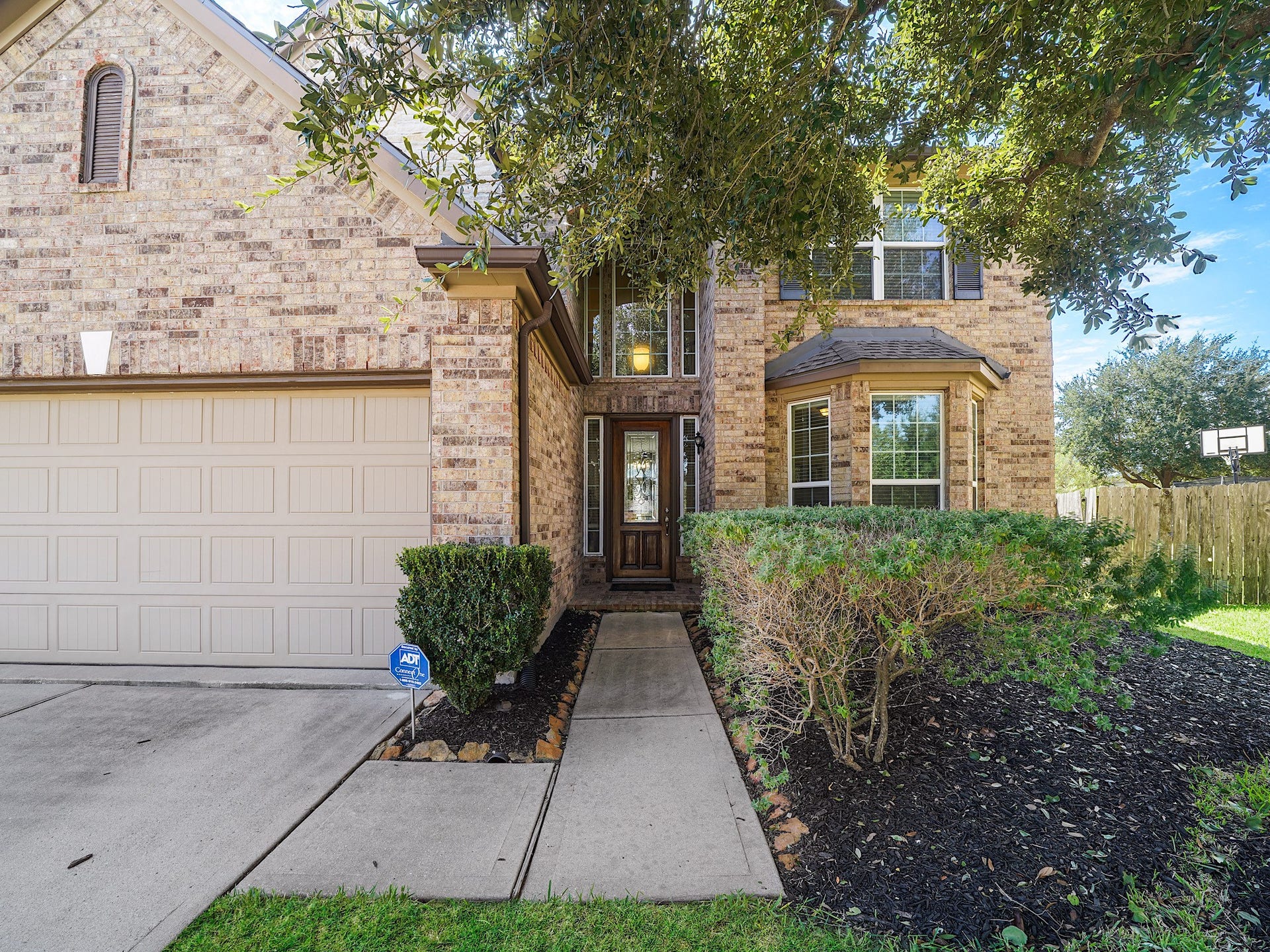 3250 Bandera Run Lane, Katy, TX 77494 Mature landscaping welcomes you along the walkway to the front door, where a striking two-story arched entry creates a grand first impression. This elegant approach sets the tone for the warmth and charm waiting inside.