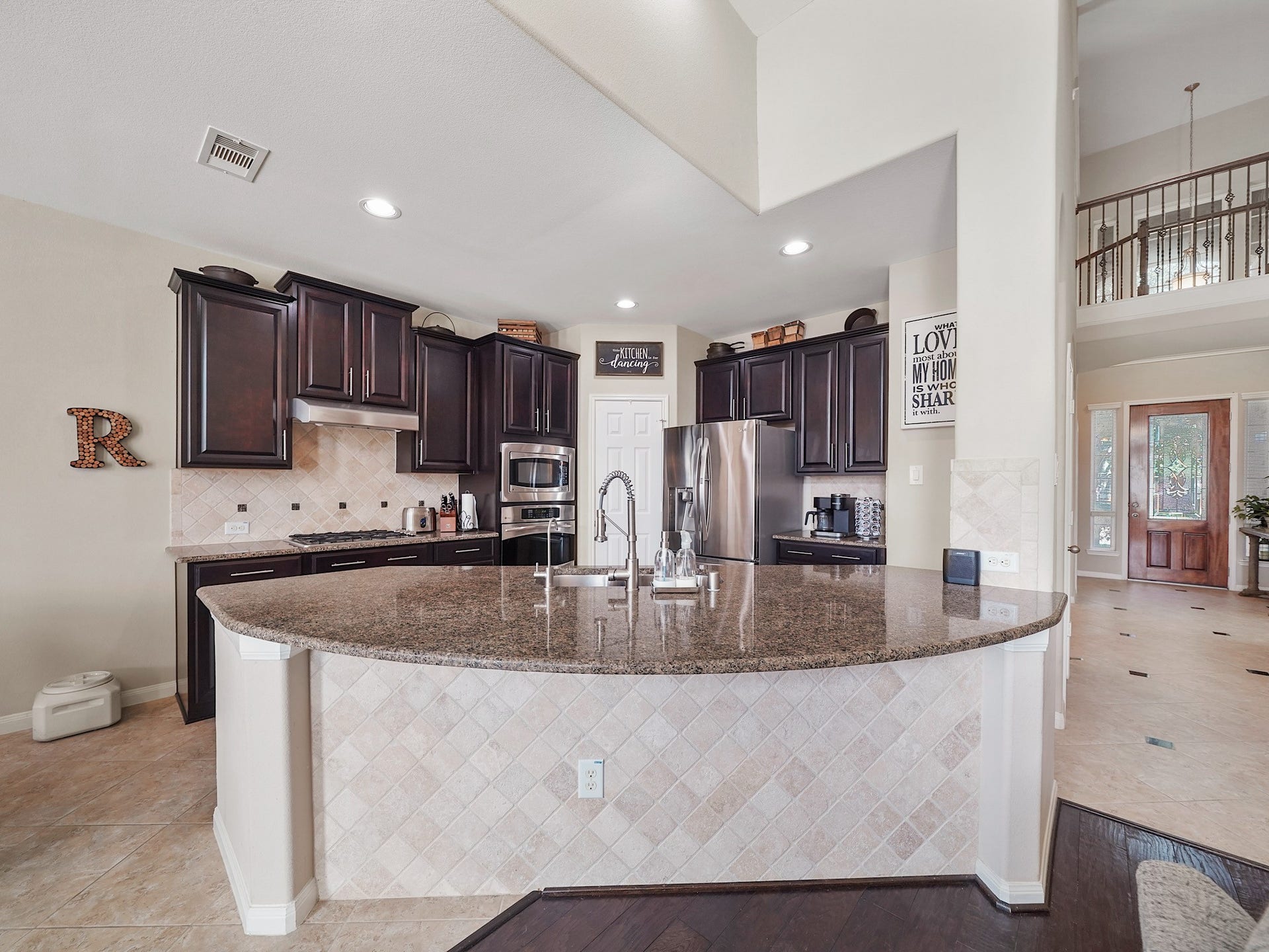 3250 Bandera Run Lane, Katy, TX 77494 Spacious kitchen with dark wood cabinetry, granite countertops, and stainless steel appliances, featuring a large island perfect for entertaining.