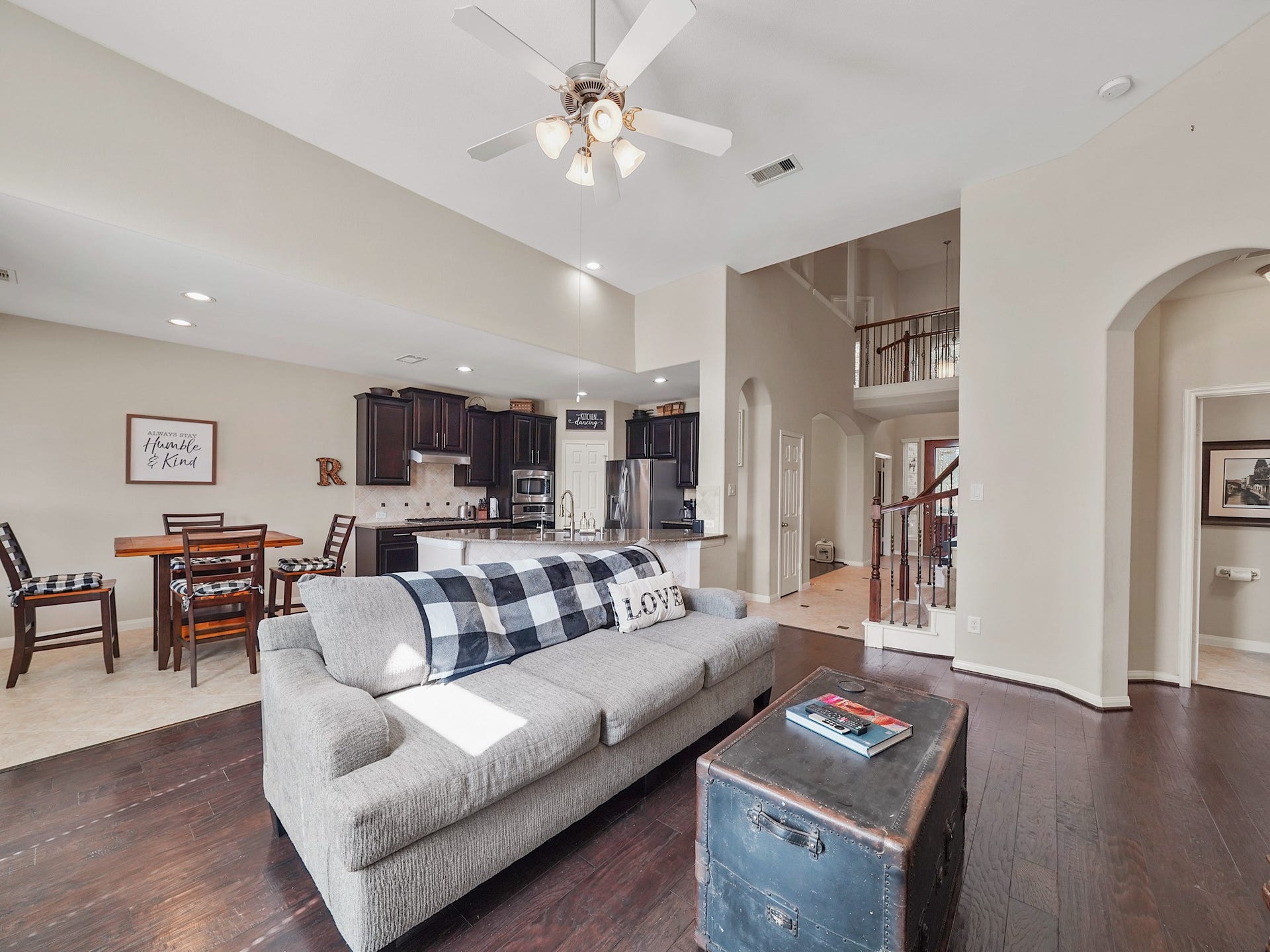 3250 Bandera Run Lane, Katy, TX 77494 High ceilings and abundant natural light create an open, welcoming atmosphere in the living area, which flows into the kitchen. Dark cabinetry and a central island add a touch of sophistication, while the open layout makes it easy to stay connected whether preparing a meal or relaxing together.