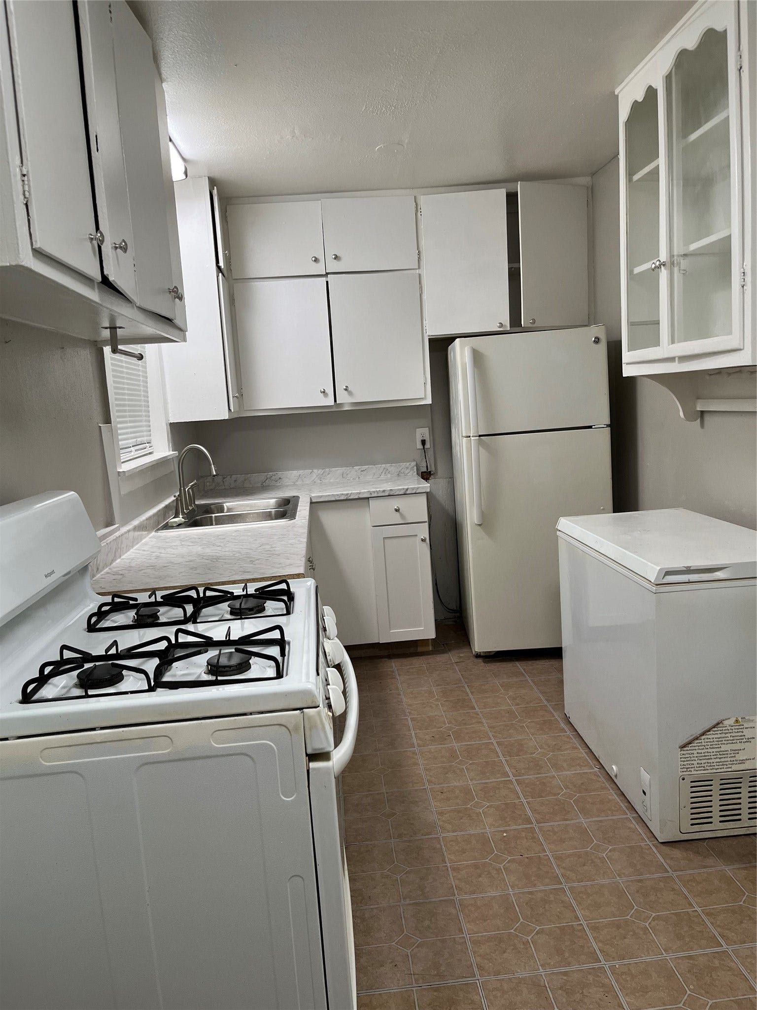 508 Honeysuckle Drive, La Marque, TX 77568 Kitchen showing, gas stove, freezer, new lower cabinets, refrigerator with lots of storage.