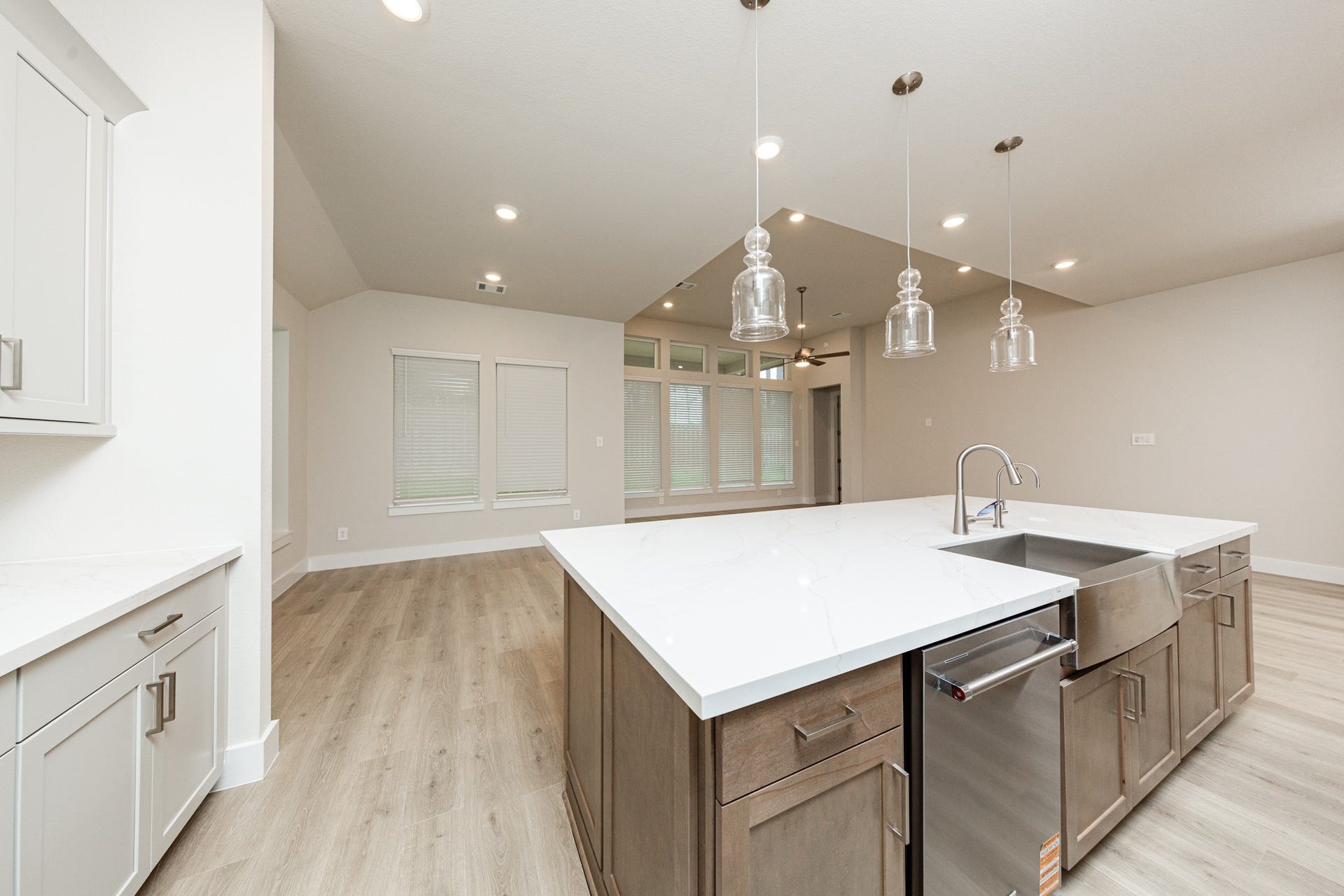 41422 Threadgill Way, Montgomery, TX 77316 The kitchen island is a stunning centerpiece that anchors the space, while the layout provides a commanding view of the adjoining living areas and beyond. It features a seamless white quartz countertop that provides a vast workspace, complete with an integrated stainless steel apron-front farmhouse sink and a sleek, high-arc faucet.