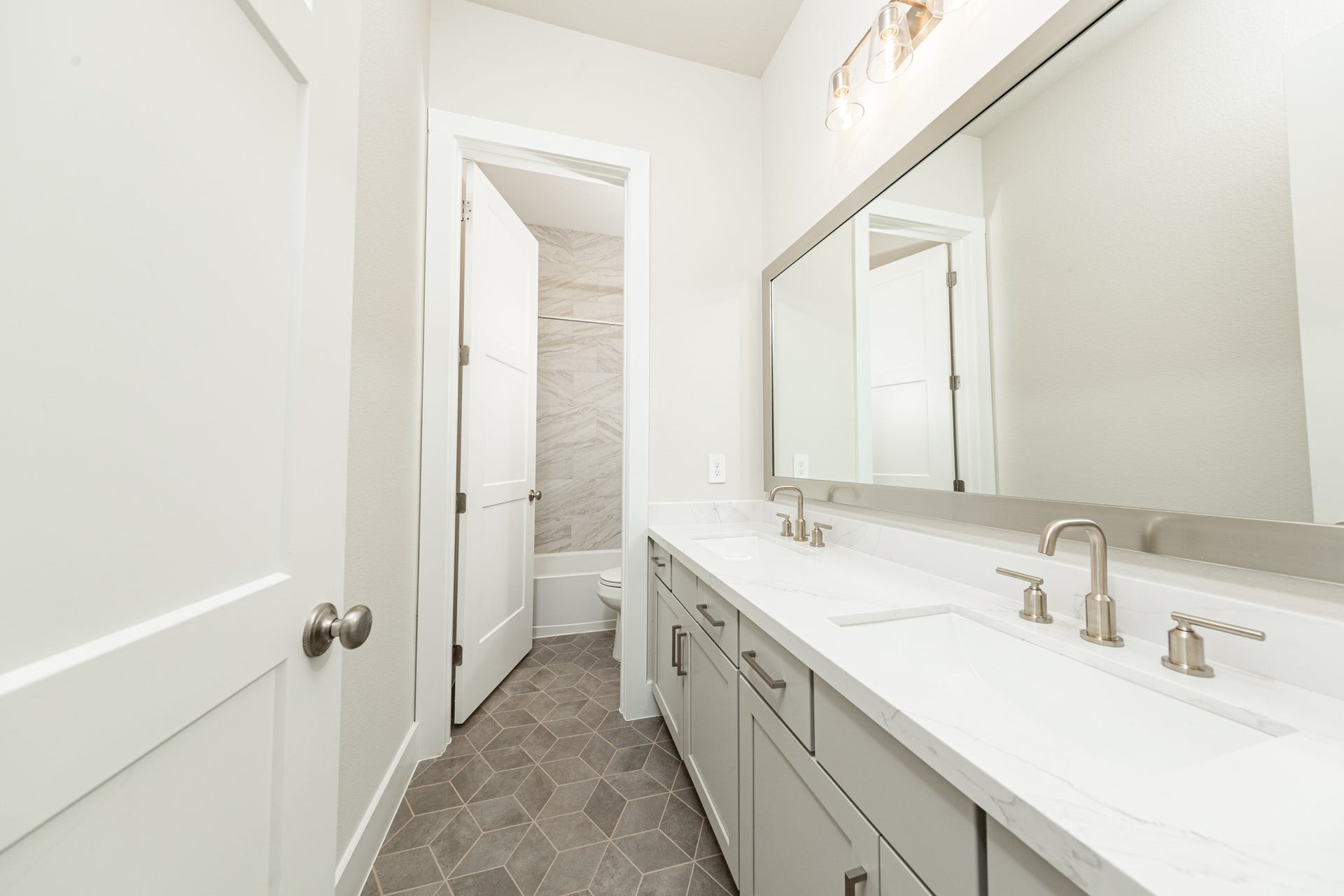 41422 Threadgill Way, Montgomery, TX 77316 The secondary bathroom features a dual vanity, framed mirror, tub/shower combination with gorgeous tile surround, and modern brushed nickel finishes.