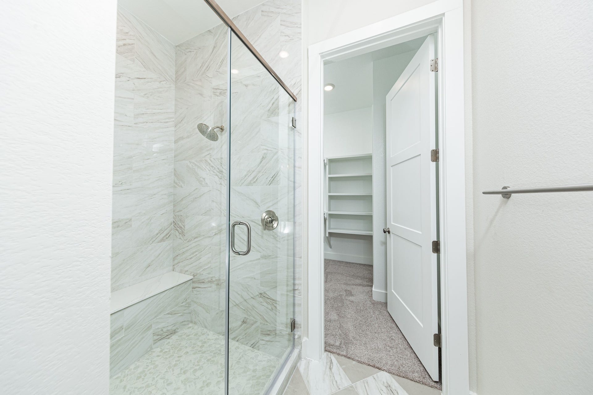 41422 Threadgill Way, Montgomery, TX 77316 The walk-in shower includes a convenient, integrated white bench, offering comfort and a high-end, custom appearance.