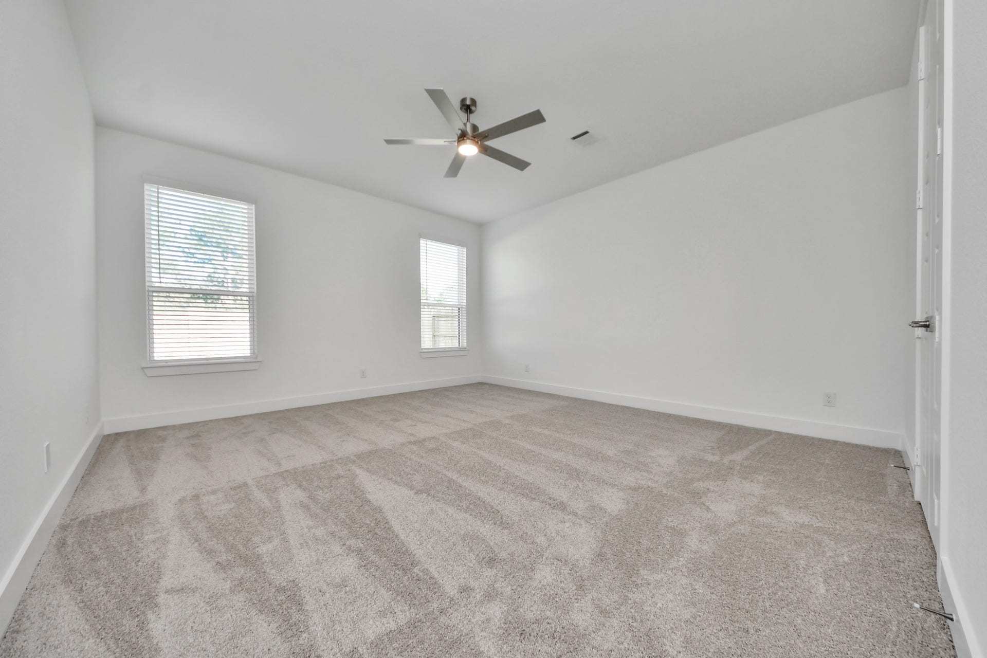 2097 Corn Thistle Way, Magnolia, TX 77355 Retreat to the luxurious primary suite, your perfect escape for unwinding after a long day. Located on the first floor, this spacious room features plush carpeting, calming paint tones, high ceilings, and large windows with privacy blinds.
