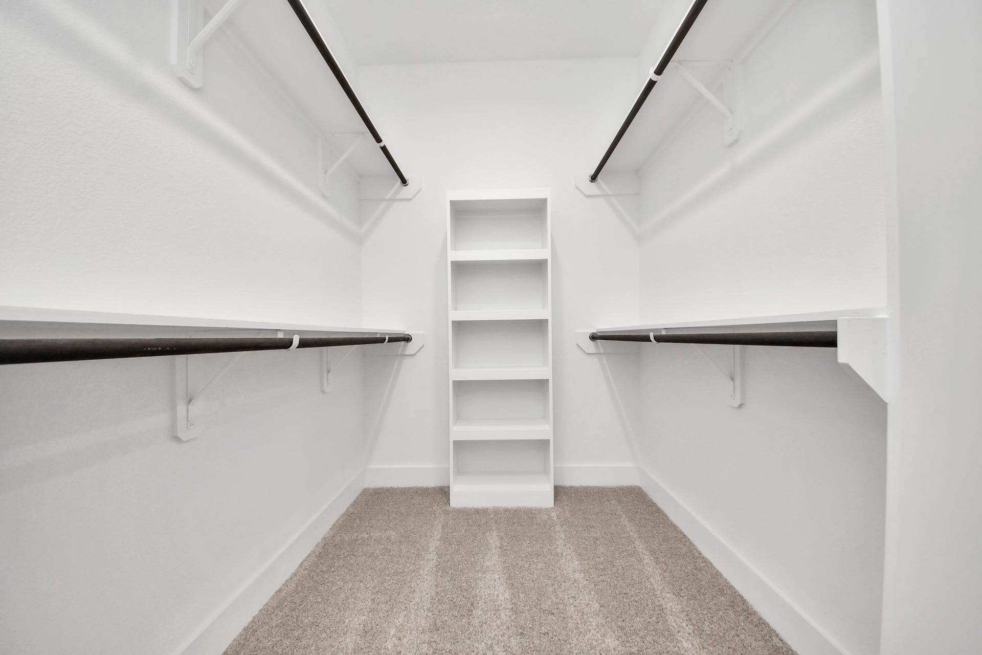 2097 Corn Thistle Way, Magnolia, TX 77355 Walk-in closet that epitomizes luxury and practicality. This generously sized space features built-in shelving, offering abundant room for impeccable organization. High ceilings and recessed lighting create a bright and welcoming ambiance.