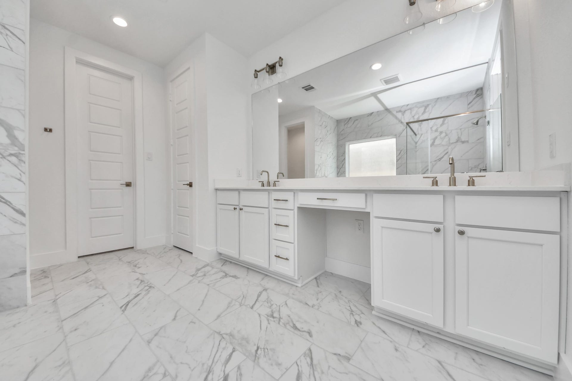 2097 Corn Thistle Way, Magnolia, TX 77355 Escape to a spa-like oasis in this primary bathroom. Enjoy a walk-in shower with tile surround, a separate garden tub with custom detailing, and an elegant vanity featuring light countertops, modern hardware, and beautiful vanity lights. Experience luxury and relaxation in every detail.
