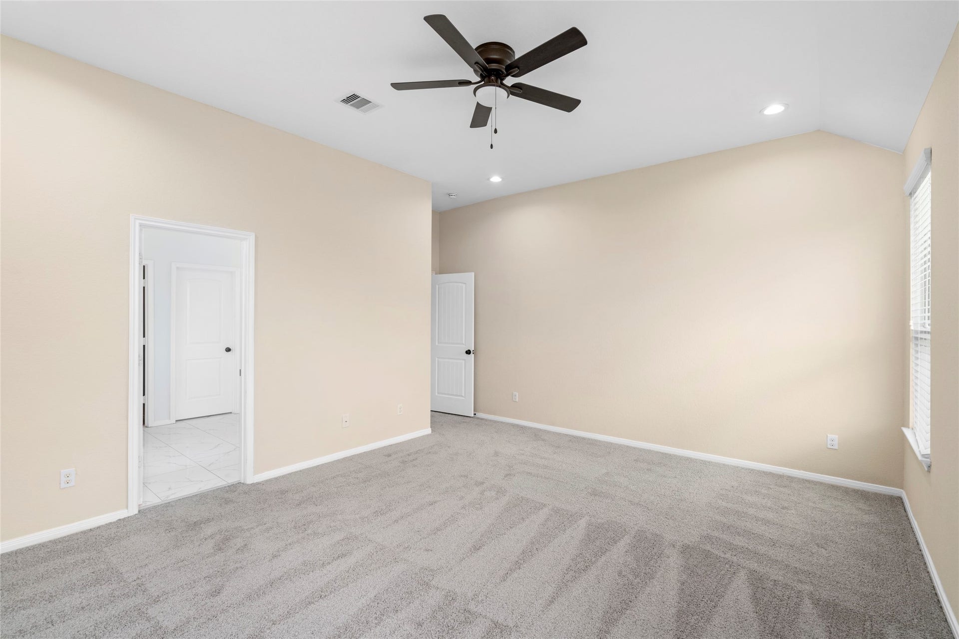 9423 Mineral Rock Lane, Richmond, TX 77407 Spacious primary bedroom on the first floor seamlessly connects to a luxurious ensuite bathroom and convenient entryway.
