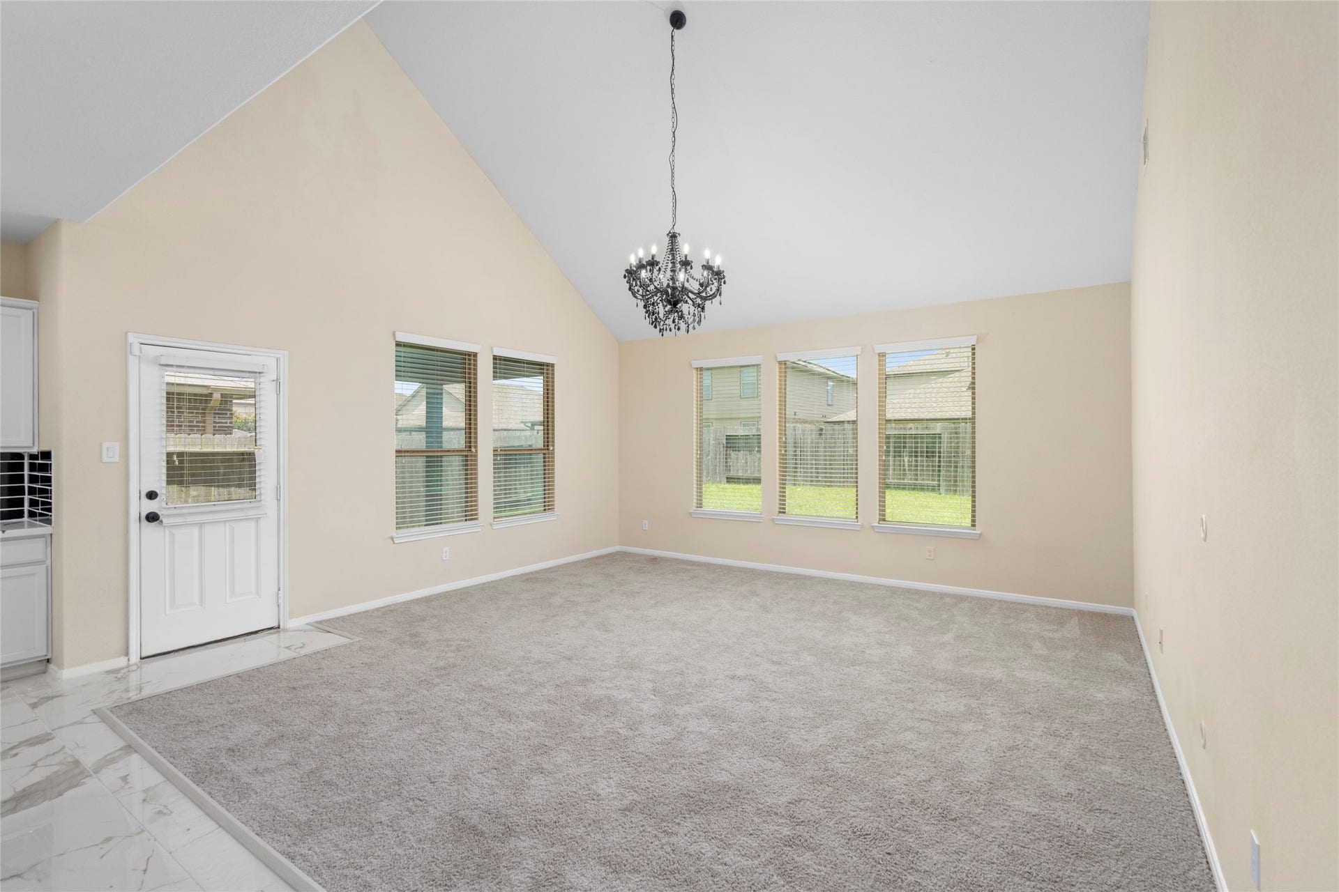 9423 Mineral Rock Lane, Richmond, TX 77407 Experience the allure of this spacious living room, featuring soaring ceilings, abundant natural light from large windows, and elegant finishes that create an inviting atmosphere for relaxation and entertaining.