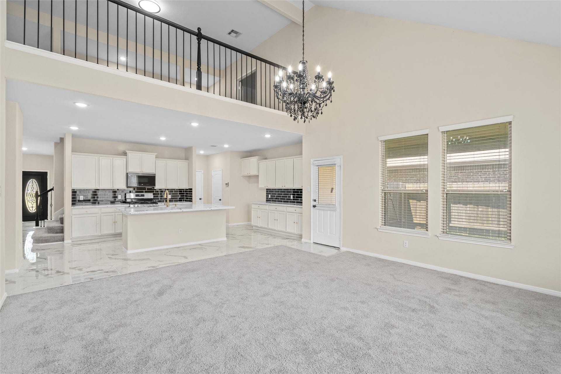 9423 Mineral Rock Lane, Richmond, TX 77407 Discover an elegant living room and kitchen combo featuring an open floor plan, high ceilings, and a stunning chandelier that adds a touch of luxury to your everyday living.