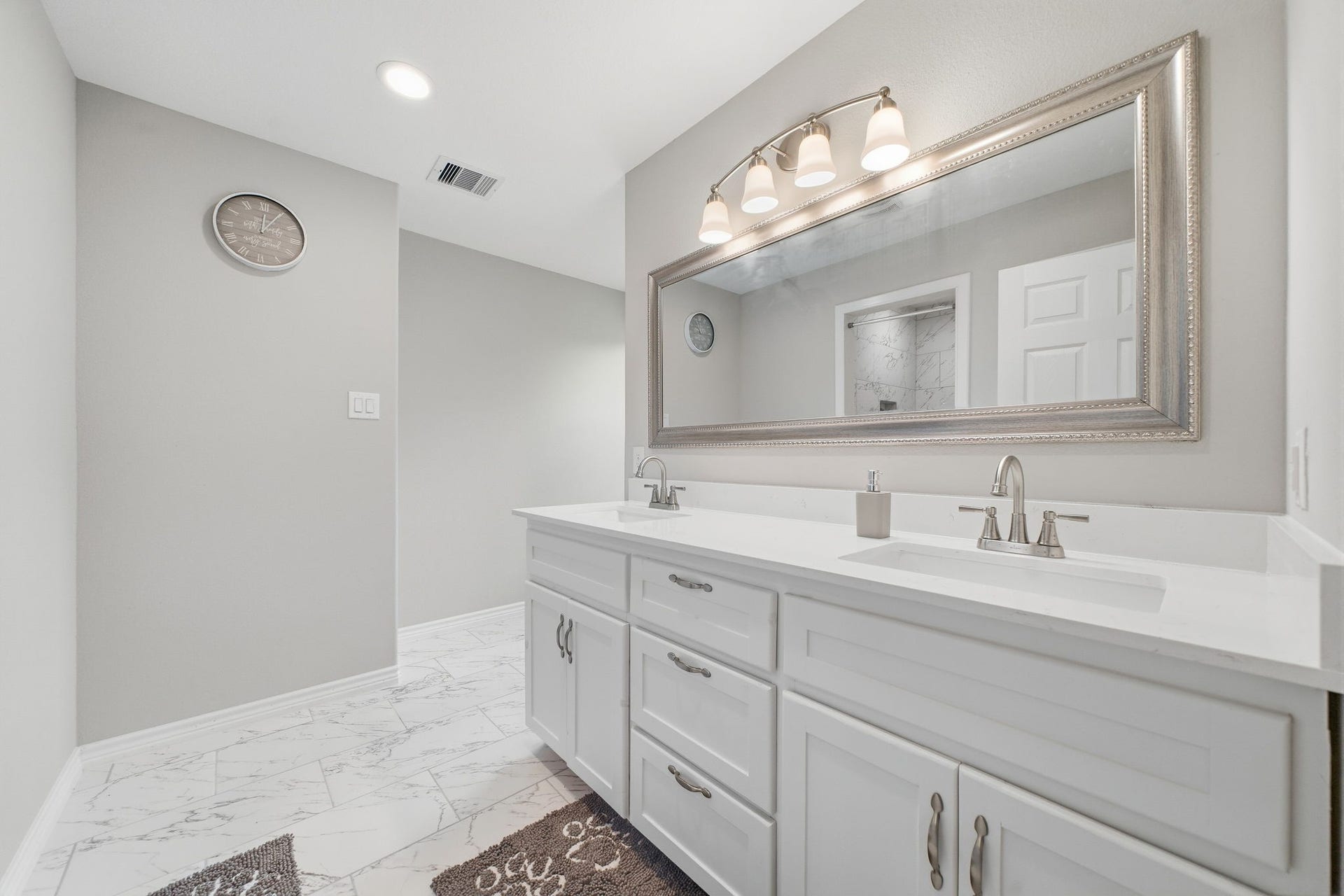 450 N Sunset Boulevard, Holiday Lakes, TX 77515 The primary en-suite bathroom features a double-sink vanity with quartz countertops, modern cabinetry, and tile flooring. An open-concept walk-in closet adds convenience and plenty of storage.