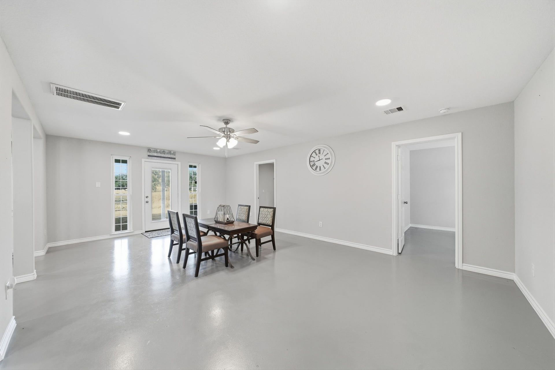 450 N Sunset Boulevard, Holiday Lakes, TX 77515 Bright, spacious open-concept living and dining area with a glass door and tall windows back entrance that fill the room with natural light, giving it a warm, modern Southern feel that's perfect any life-style.