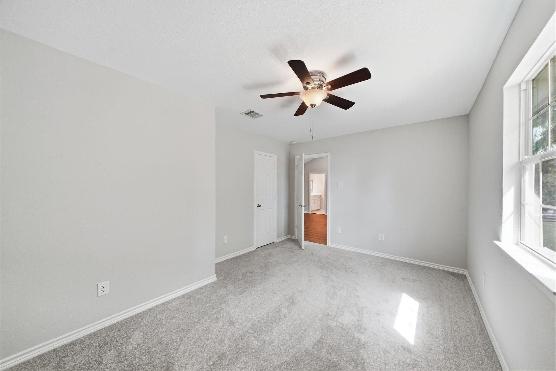450 N Sunset Boulevard, Holiday Lakes, TX 77515 Upstairs bedroom, soft carpet, and natural light from large windows.