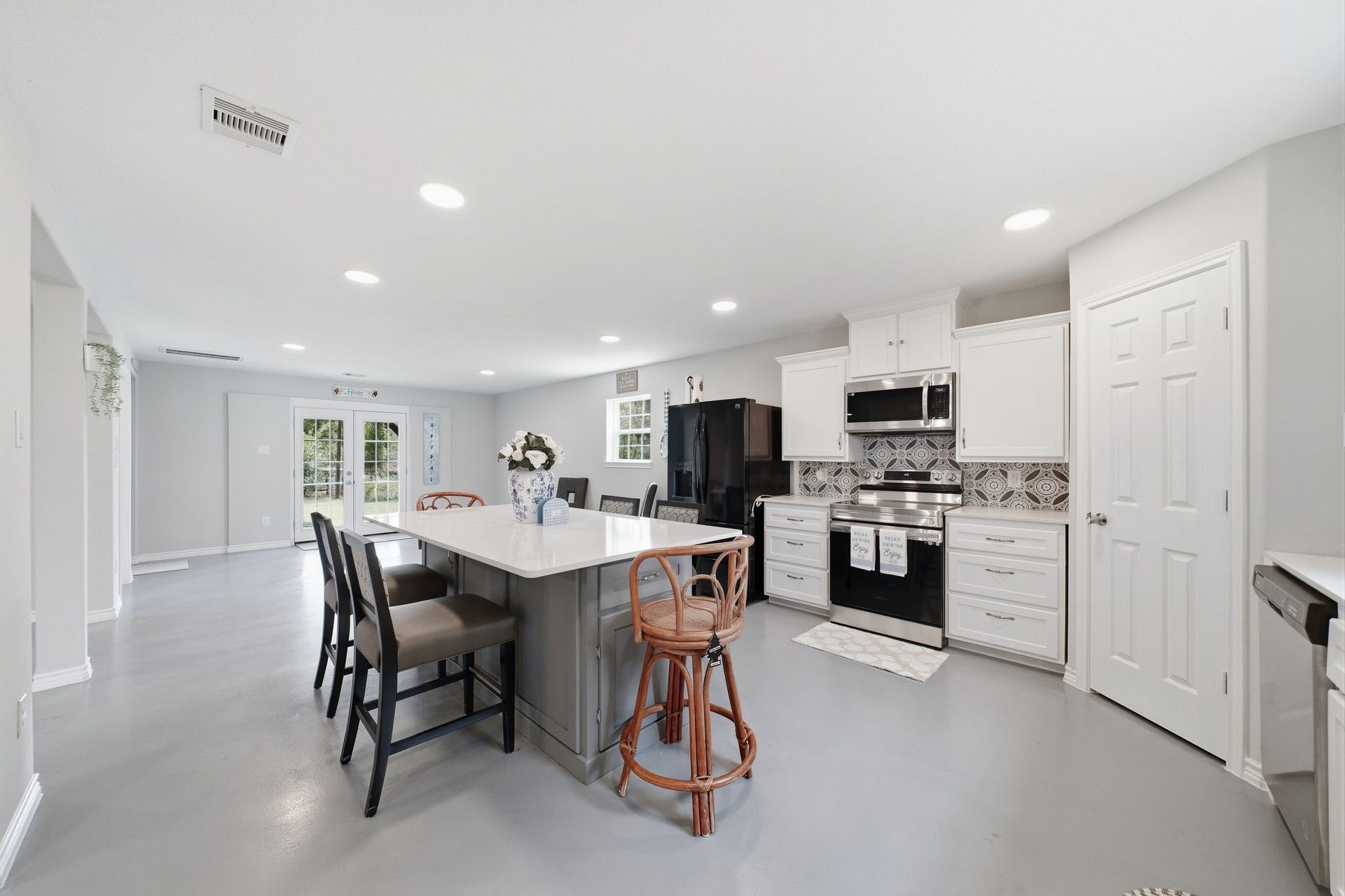 450 N Sunset Boulevard, Holiday Lakes, TX 77515 Stainless dishwasher, range, and microwave, plus a black French-door refrigerator with ice and water. Tall pantry cabinets provide room for everything.