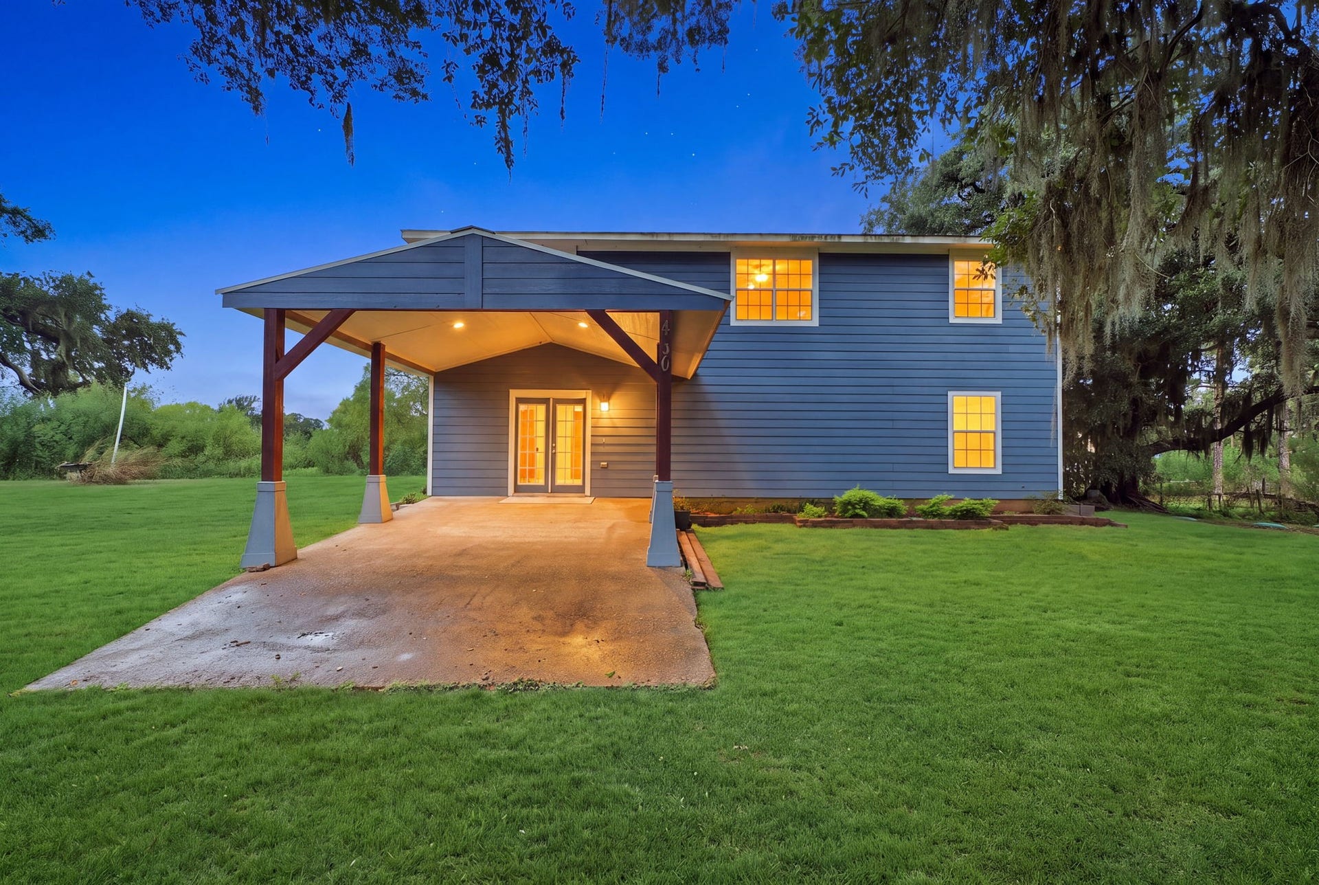 450 N Sunset Boulevard, Holiday Lakes, TX 77515 Front Exterior: A covered carport with French doors makes coming home easy, even on rainy days. The open lot offers lots of space for kids to play, gardening and own house projects.