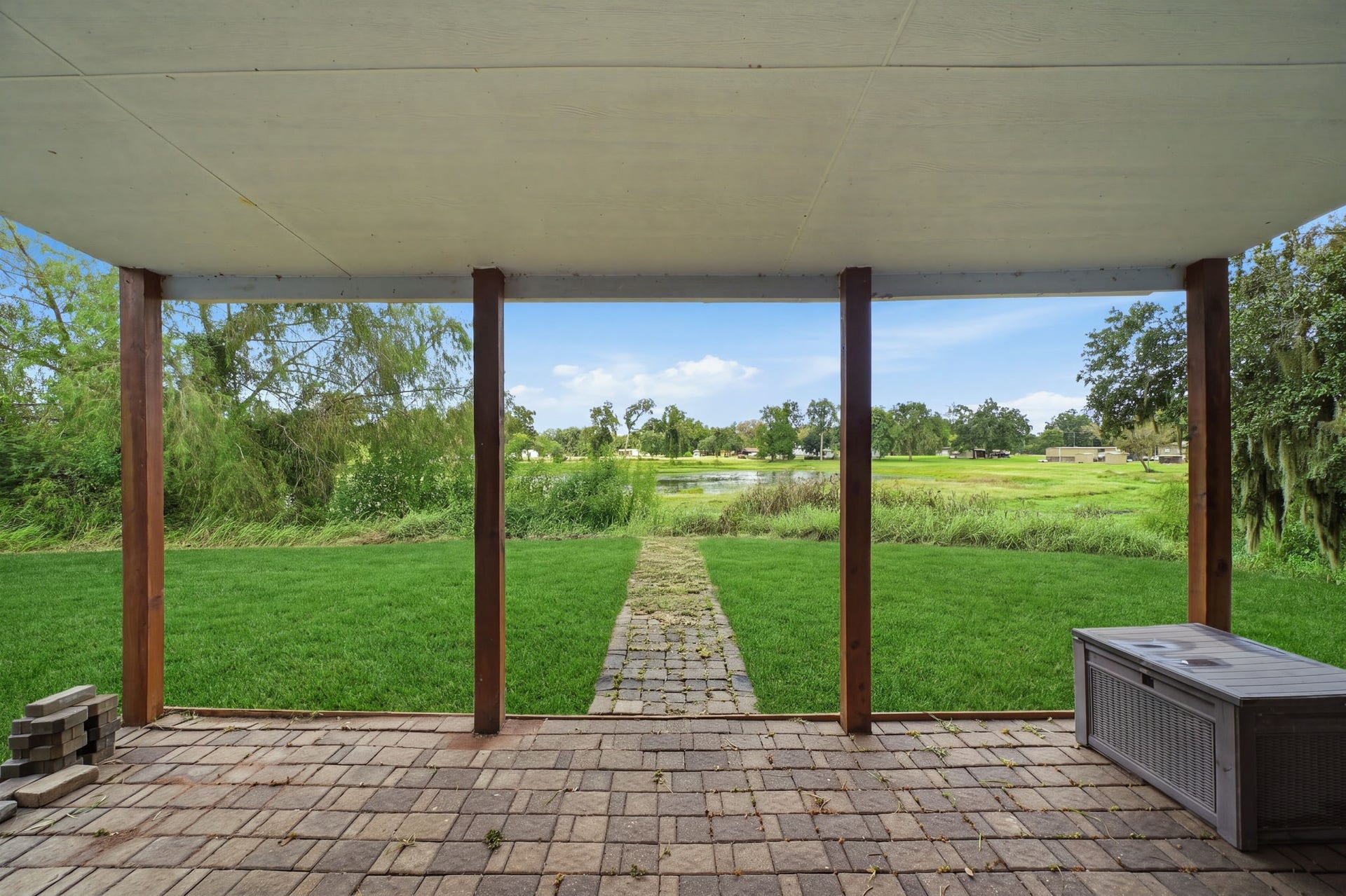 450 N Sunset Boulevard, Holiday Lakes, TX 77515 This covered brick-paver patio looks out over the pond and open lawn. Create your dream BBQ area, outdoor dining space, or enclosed sunroom with water views.