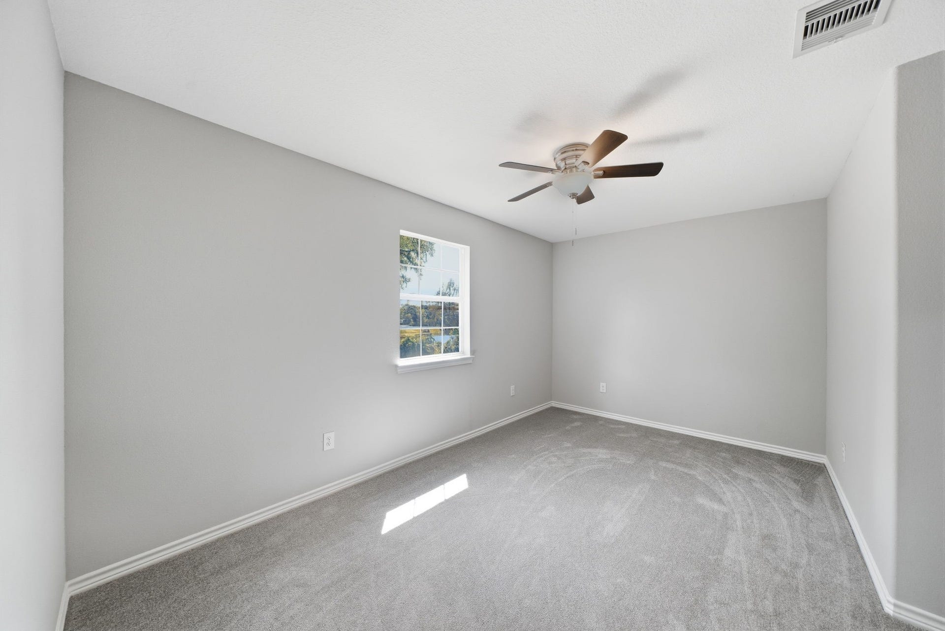 450 N Sunset Boulevard, Holiday Lakes, TX 77515 Third upstairs bedroom with large windows and lake view, fill the room with natural light. Plush carpet and ample space.
