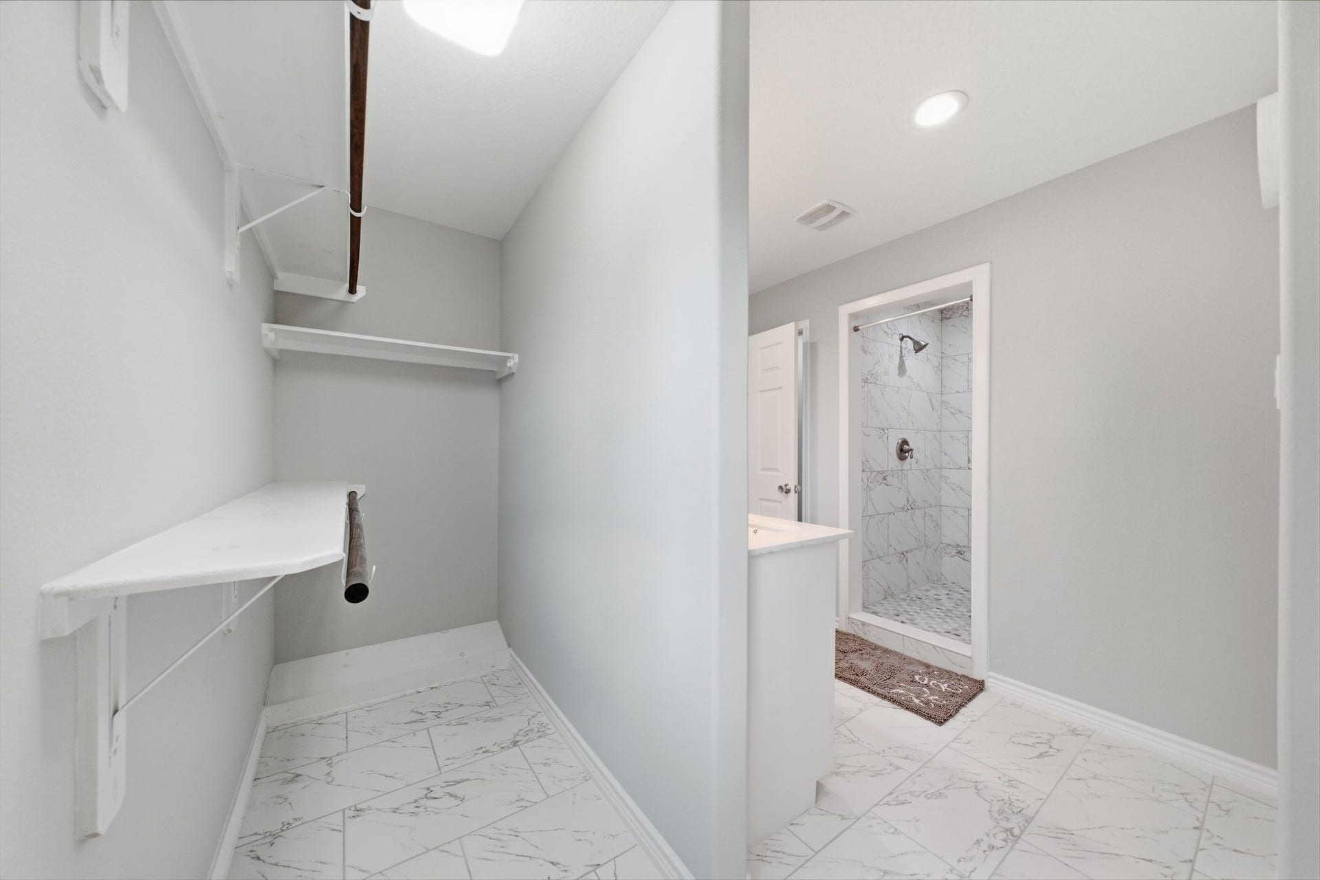 450 N Sunset Boulevard, Holiday Lakes, TX 77515 The primary en-suite bathroom features tile walk-in shower, modern cabinetry, and tile flooring. An open-concept walk-in closet adds convenience and plenty of storage.