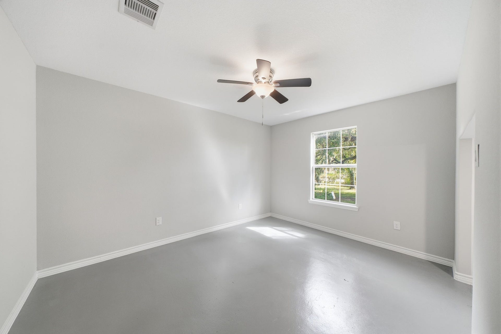 450 N Sunset Boulevard, Holiday Lakes, TX 77515 Large downstairs bedroom with a bright window and views of the oaks.