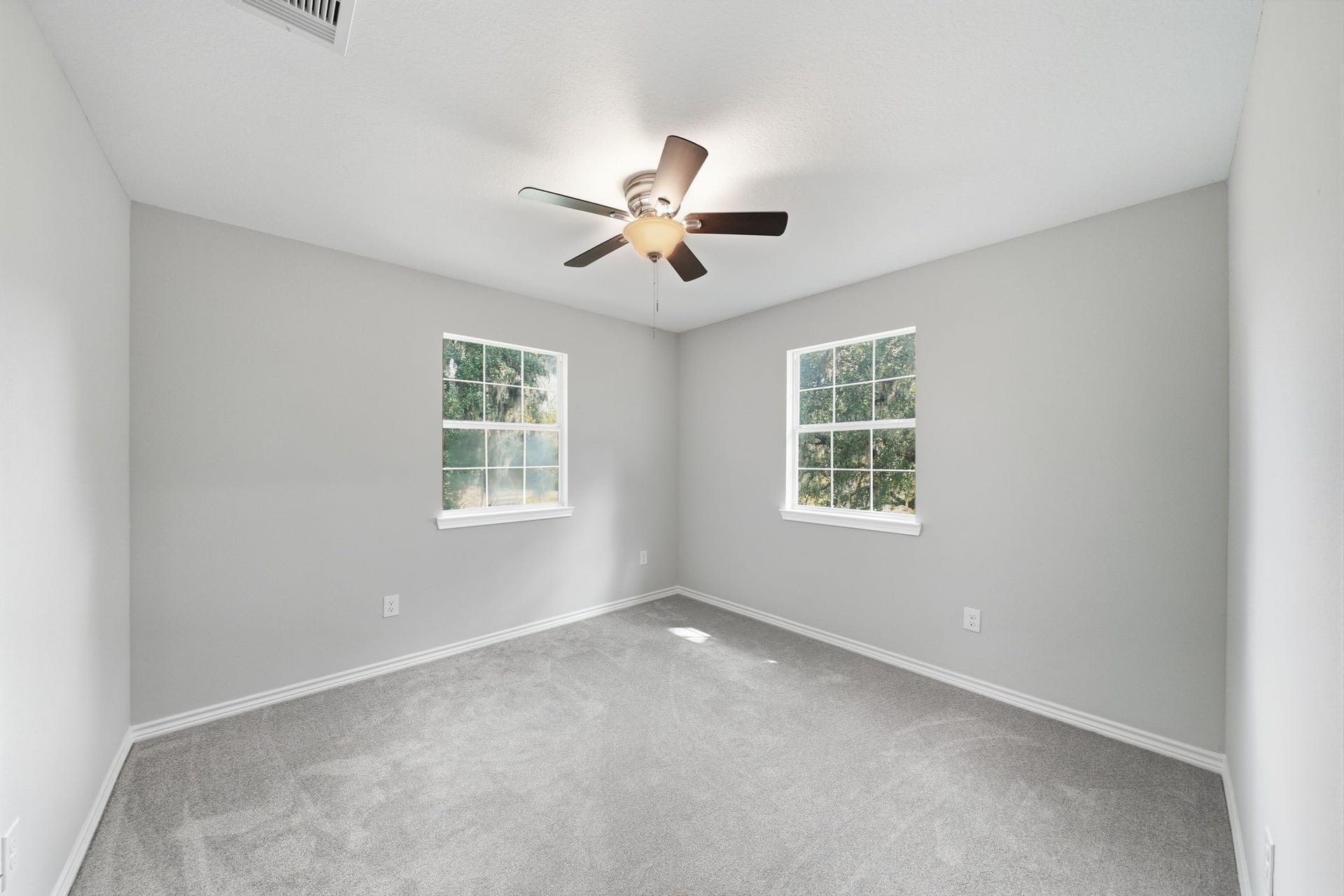 450 N Sunset Boulevard, Holiday Lakes, TX 77515 Corner bedroom where large windows fill the room with natural light. Plush carpet and ample space make it a comfortable space.