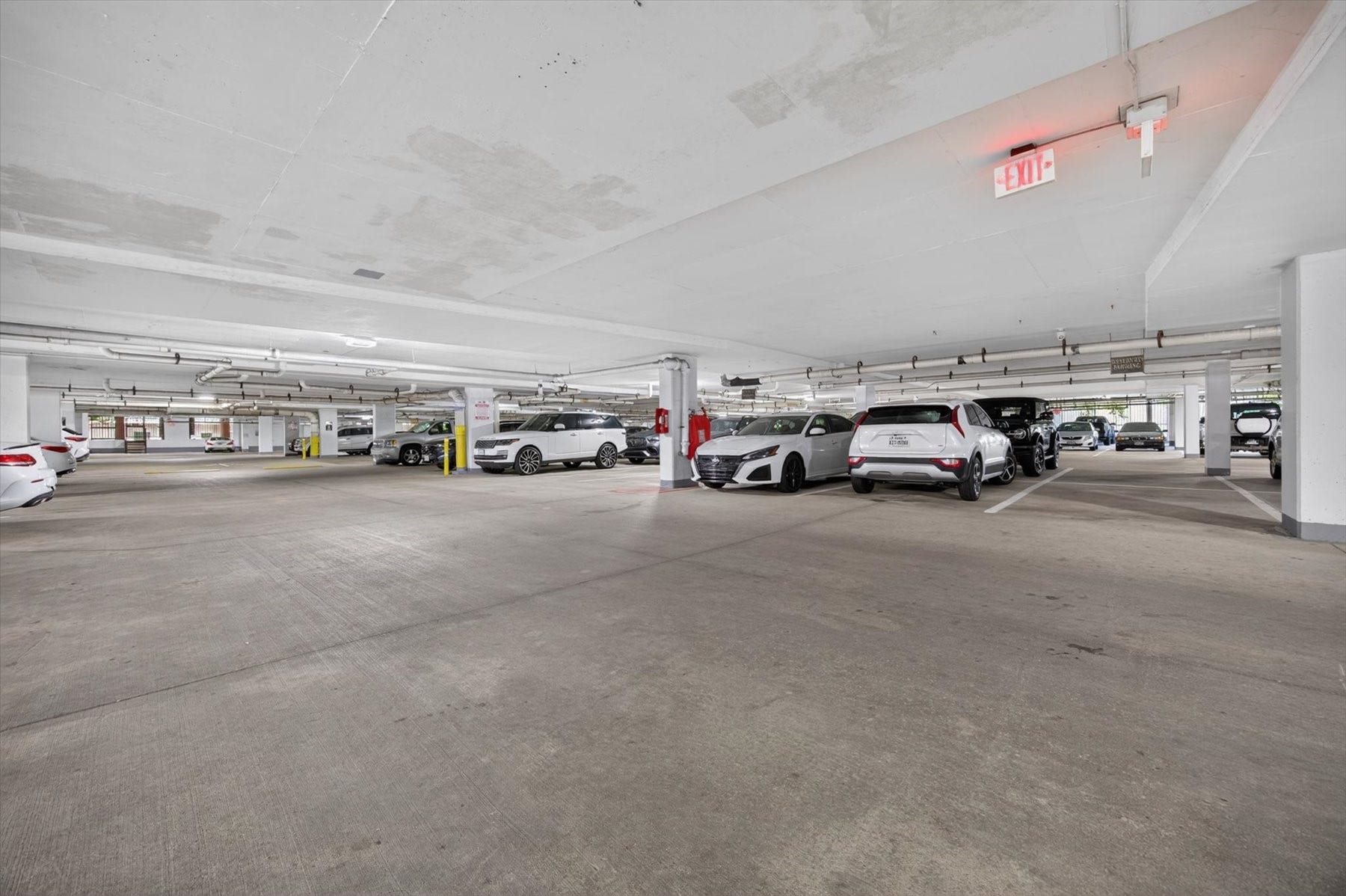 Gated underground parking garage with ample lighting and designated parking spaces for convenience and security.