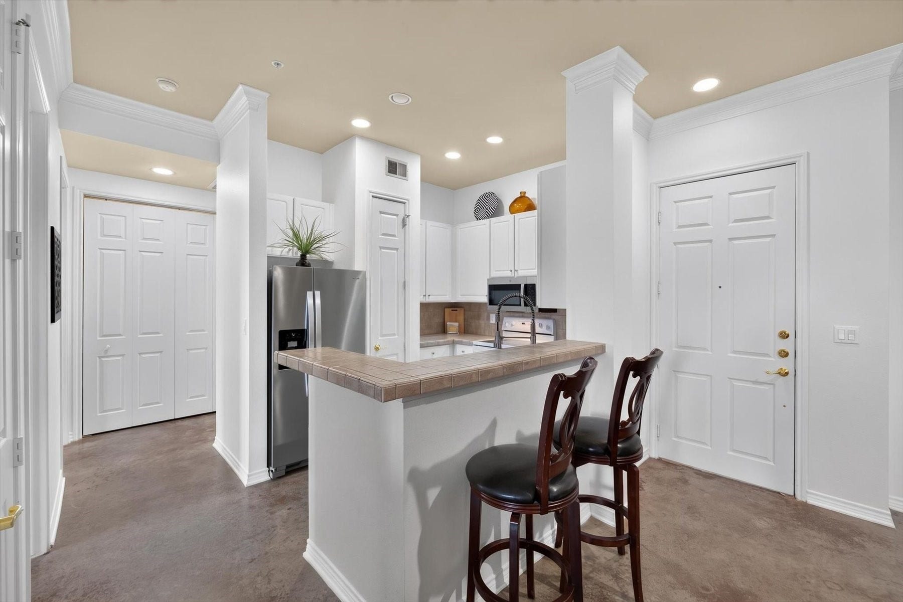 Modern kitchen with sleek stainless steel appliances, a convenient breakfast bar with seating, and ample cabinetry for storage.