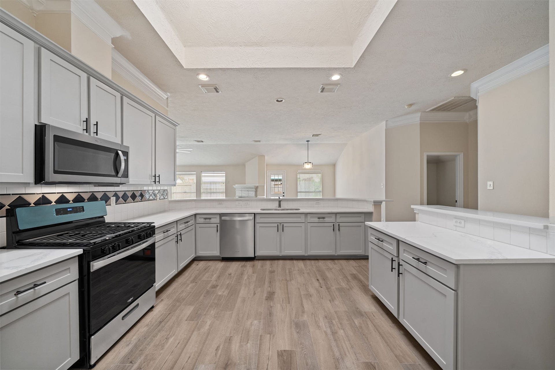 10902 Trail Ridge Drive, Houston, TX 77064 Spacious Renovated kitchen featuring stainless steel appliances, sleek gray cabinetry, new hardware, and Quartz countertops