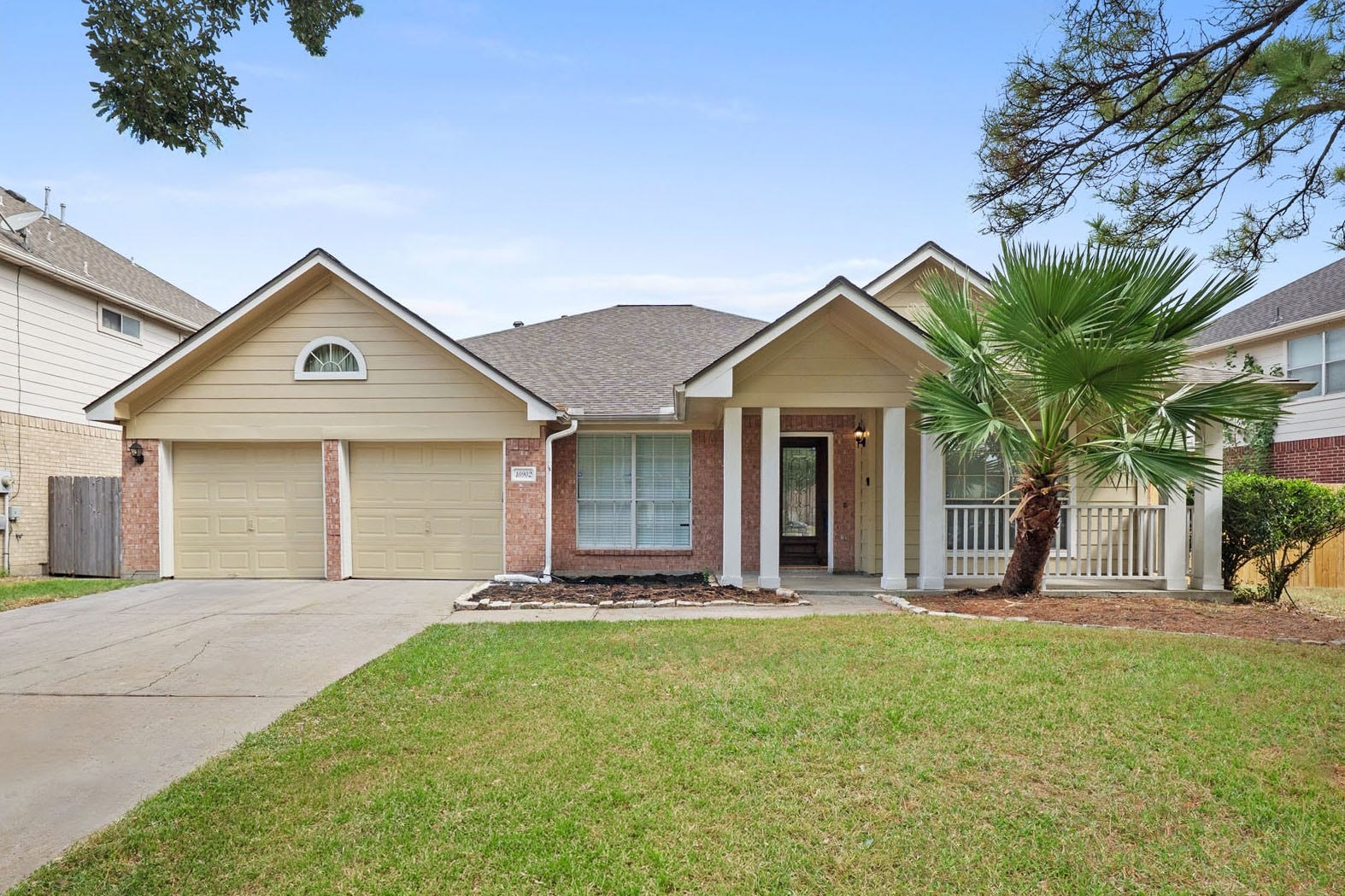 10902 Trail Ridge Drive, Houston, TX 77064 Charming single-story home with a New Roof (June 2026), welcoming front porch, dual garage doors, and a well-maintained lawn, accented by a mature palm tree.