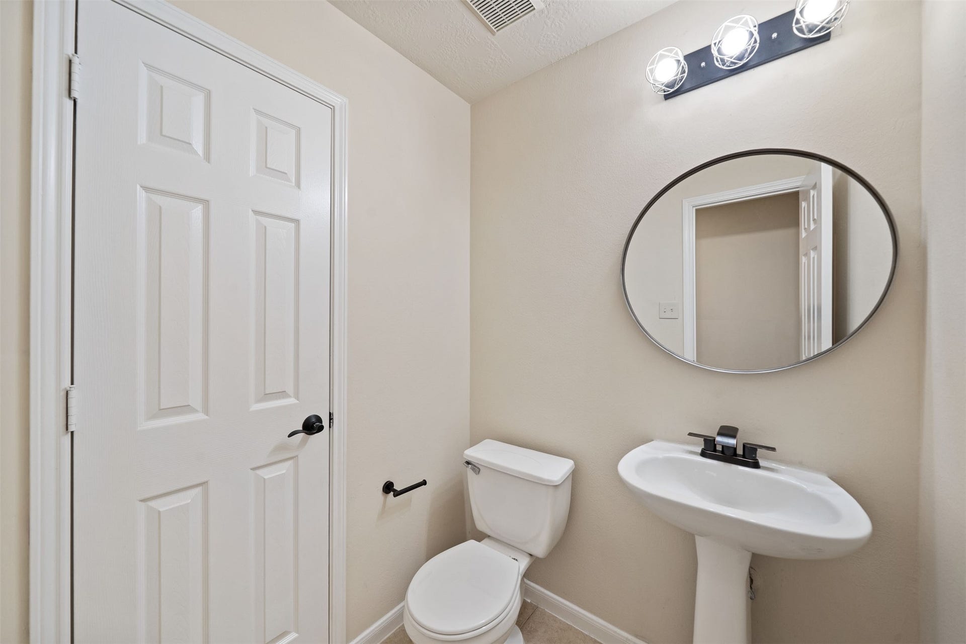 10902 Trail Ridge Drive, Houston, TX 77064 Charming powder room with a sleek pedestal sink, modern mirror, and bright lighting, offering a clean and functional space.