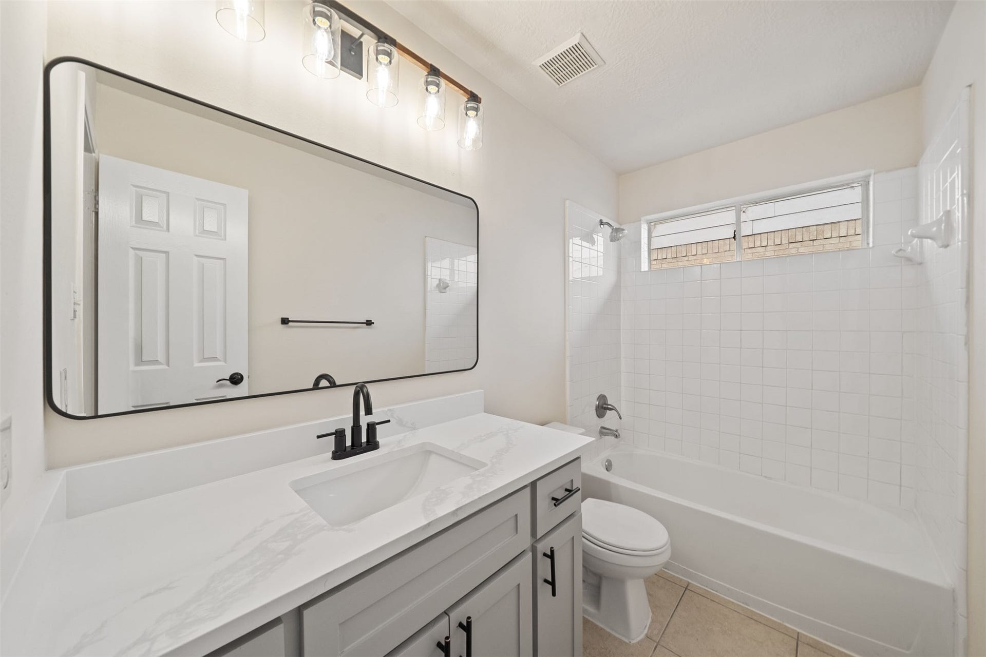 10902 Trail Ridge Drive, Houston, TX 77064 Bright and modern 2nd full bathroom featuring a sleek vanity with a Quartz countertop, large mirror, and a classic tub-shower combo.