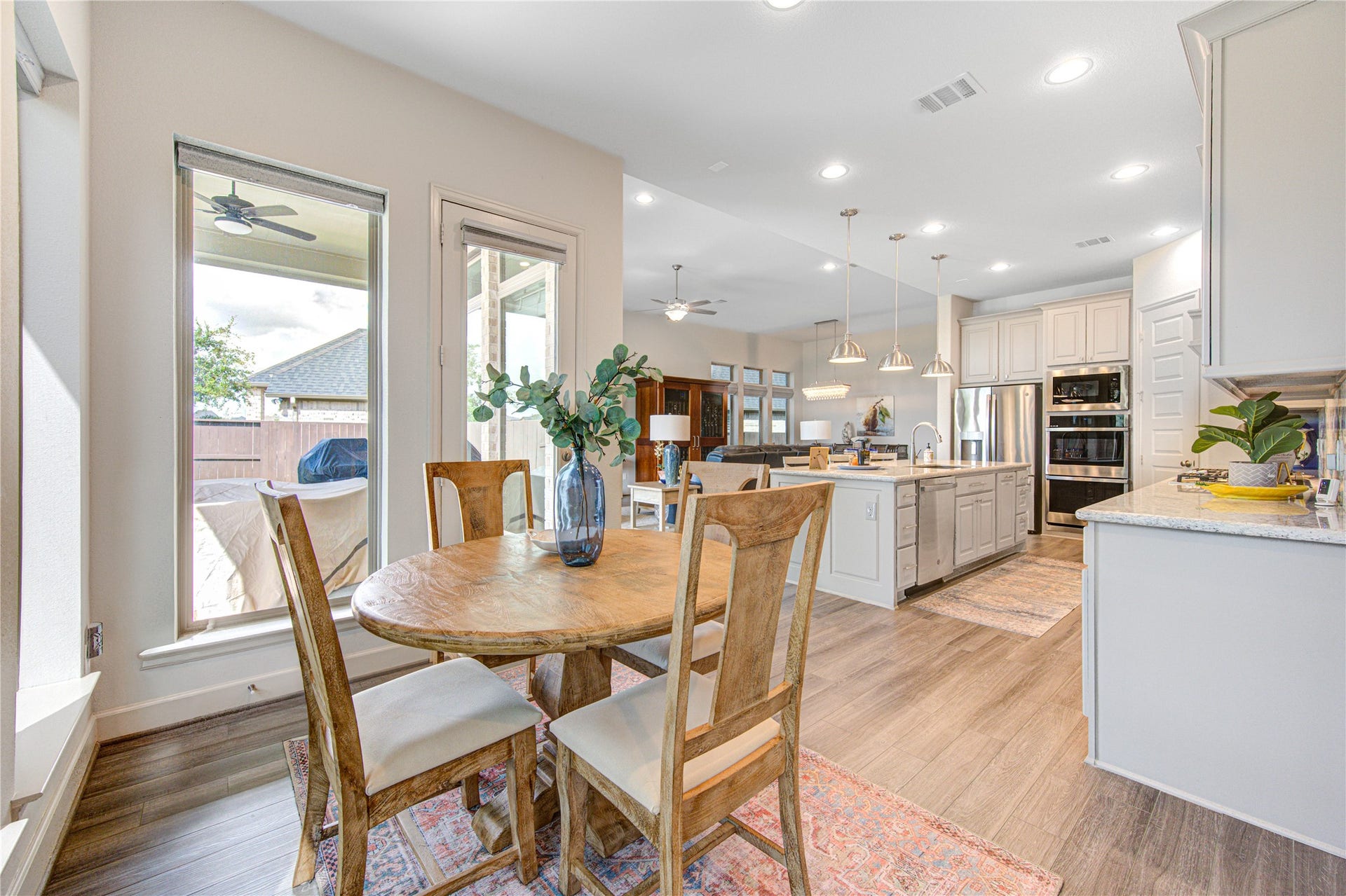 An abundance of natural light pours in through large windows, offering breathtaking lake views as you prepare meals. The marble tile backsplash adds a touch of modern elegance, while under-cabinet lighting enhances both ambiance and practicality. A walk-in pantry provides ample storage space, keeping everything organized and within reach.