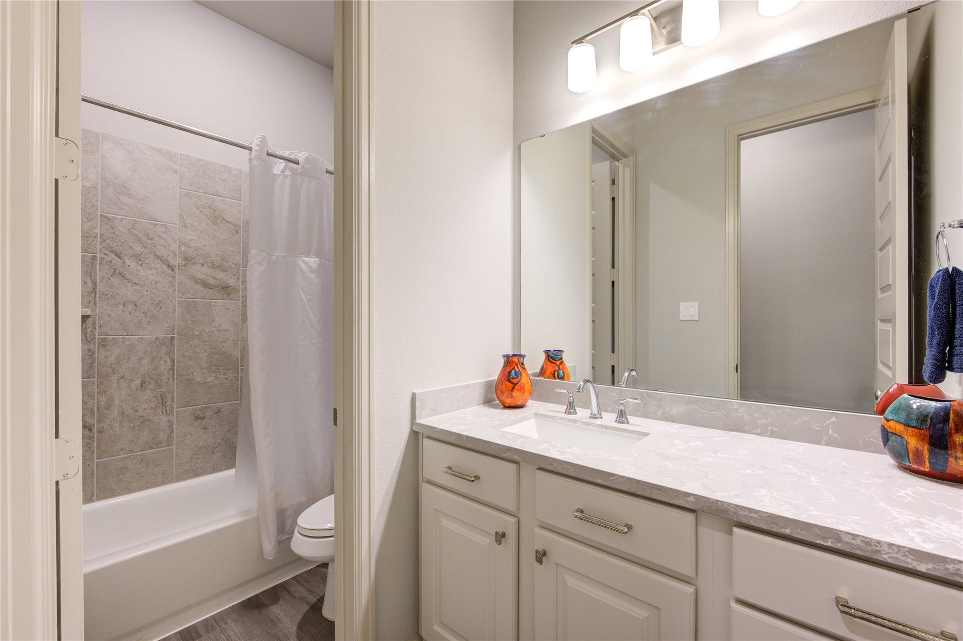 The third bathroom offers a perfect blend of style and convenience, featuring a Quartz countertop vanity with ample storage and modern brushed nickel fixtures. The soft neutral color palette enhances the bright and airy feel of the space.

A full-size bathtub with a tiled surround provides versatility, ideal for both relaxing soaks and practical everyday use