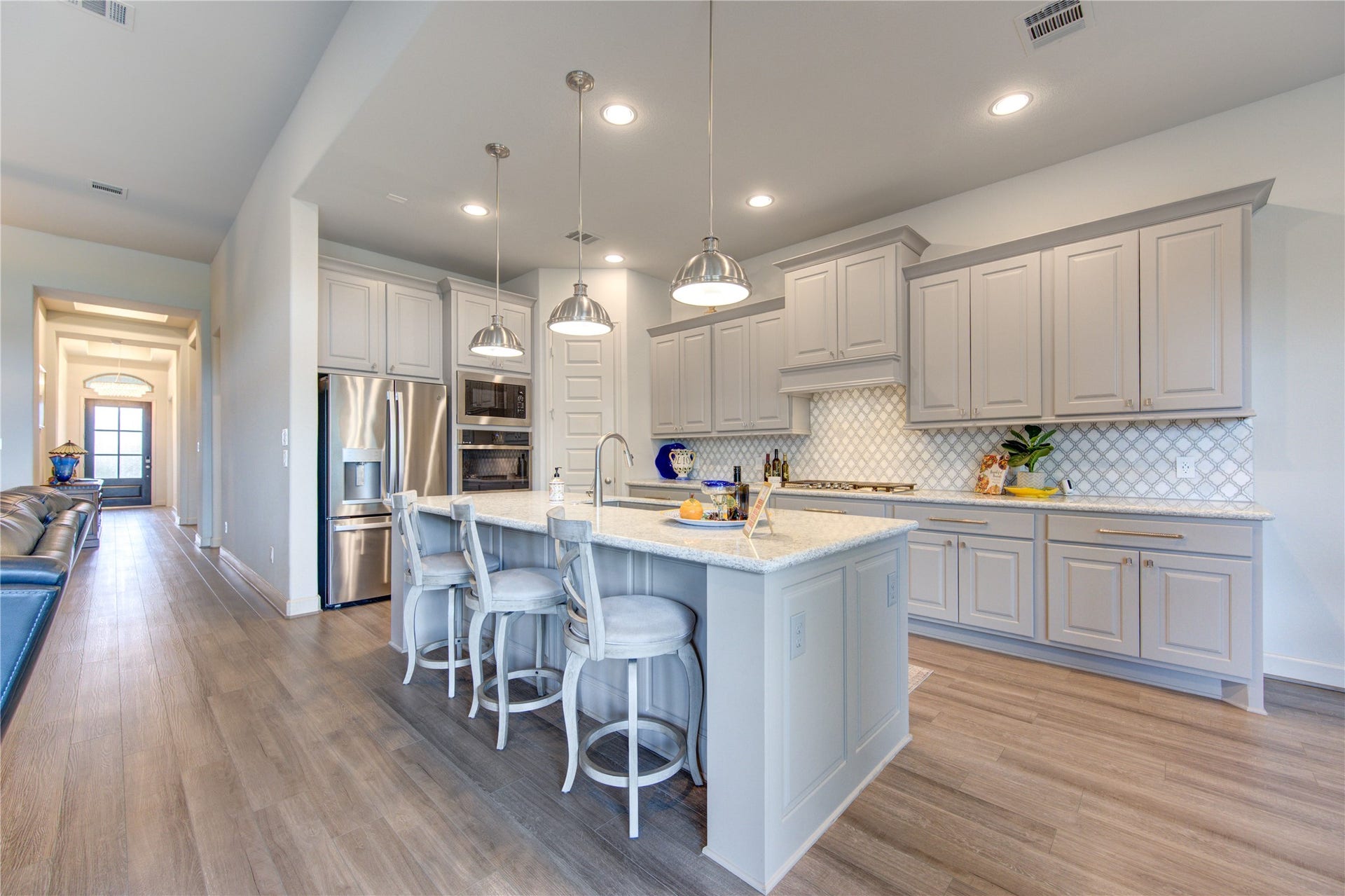 This chef-inspired kitchen is designed for both beauty and functionality, featuring sleek Quartz countertops, custom cabinetry, and a spacious island with bar seatingperfect for casual dining or entertaining guests. High-end stainless steel appliances, including a gas cooktop and built-in oven, ensure a seamless cooking experience.