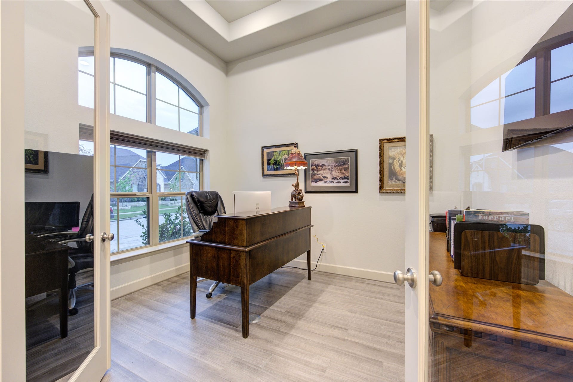 Private Study with a View: Ideal for remote work, this dedicated home office features elegant French doors, built-in shelving, and large windows offering inspiring views of the front lawn.