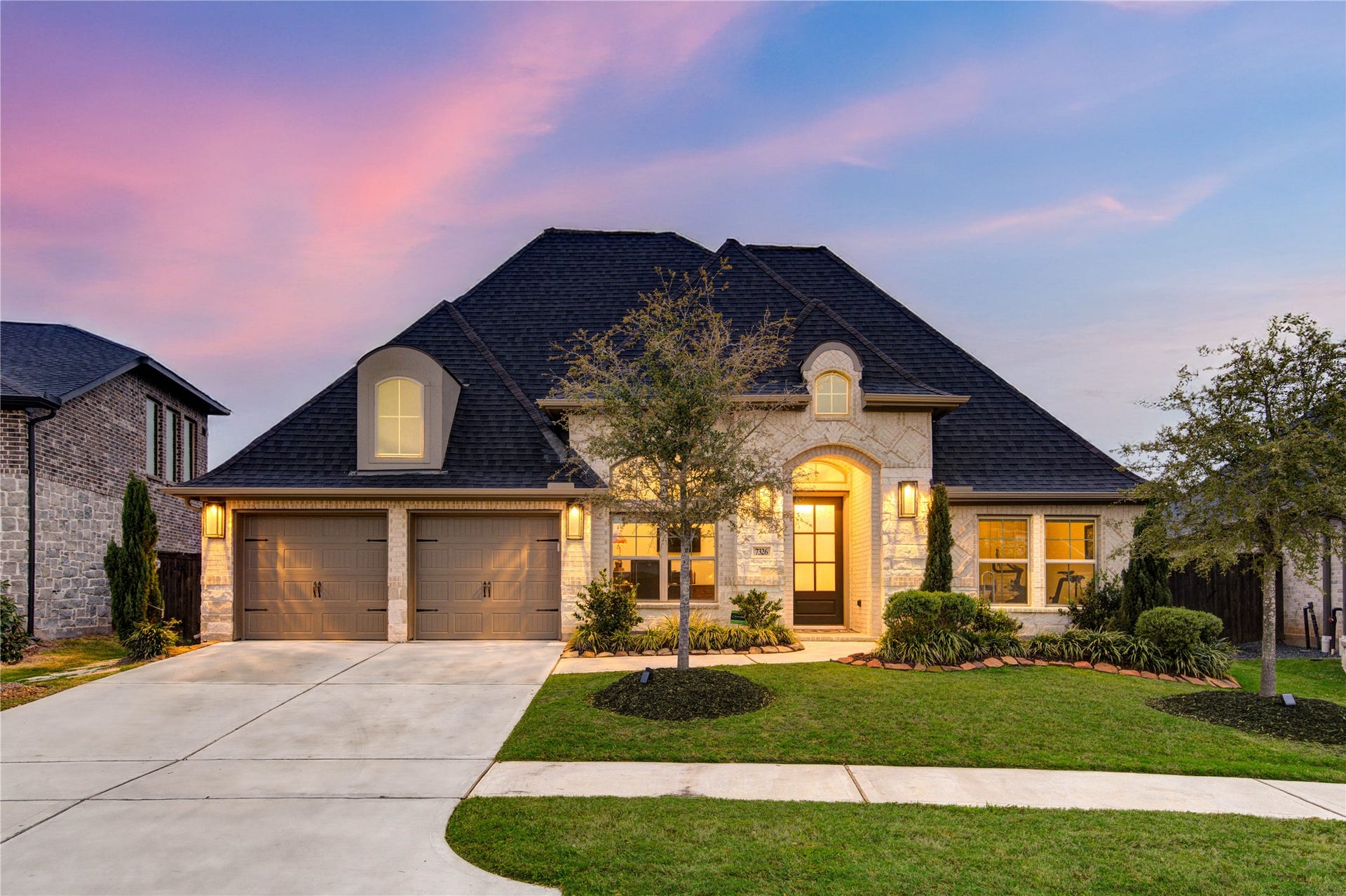 This stunning one-story home boasts an elegant brick and stone exterior with manicured landscaping and a charming covered entryway. The lush green lawn and mature trees enhance the homes curb appeal. Built in 2022, this home is like new construction.