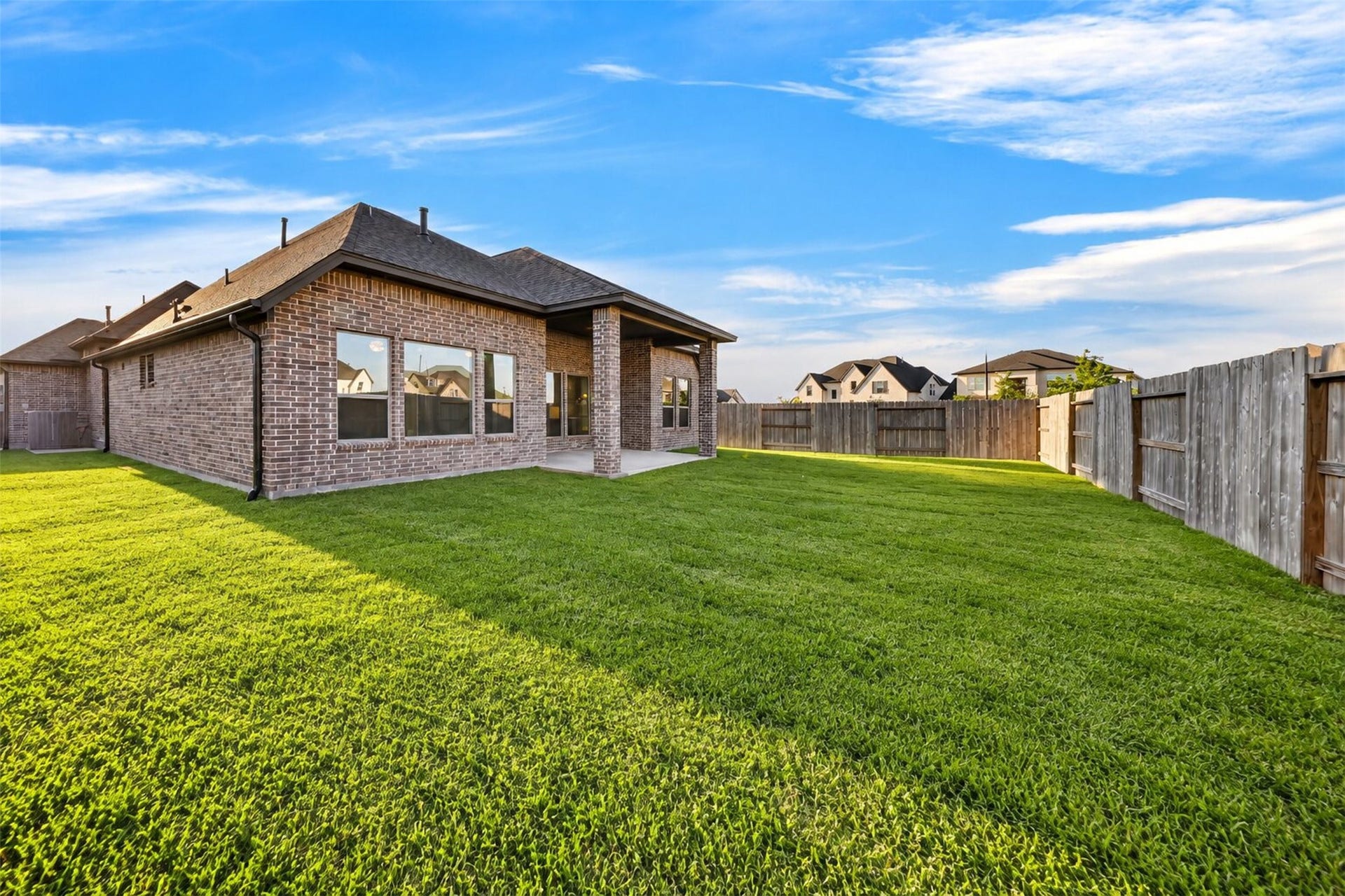 16270 Blue Mistflower Lane, Hockley, TX 77447 Backyard Additional View: Expansive backyard showcasing a beautiful lawn, privacy fencing, and an inviting covered patio with plenty of room to relax, entertain, and enjoy the outdoors.