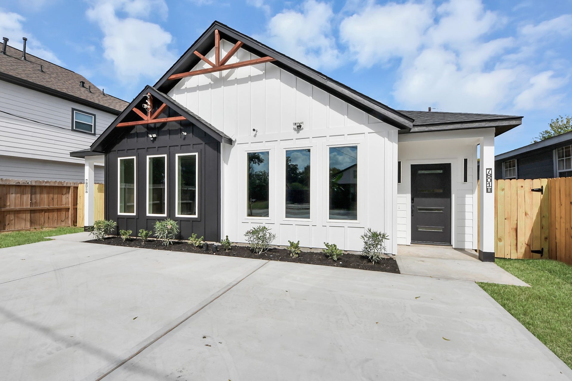 7801 King Street, Houston, TX 77028 Chic modern home with a striking black-and-white exterior, large windows, and a welcoming front porch.