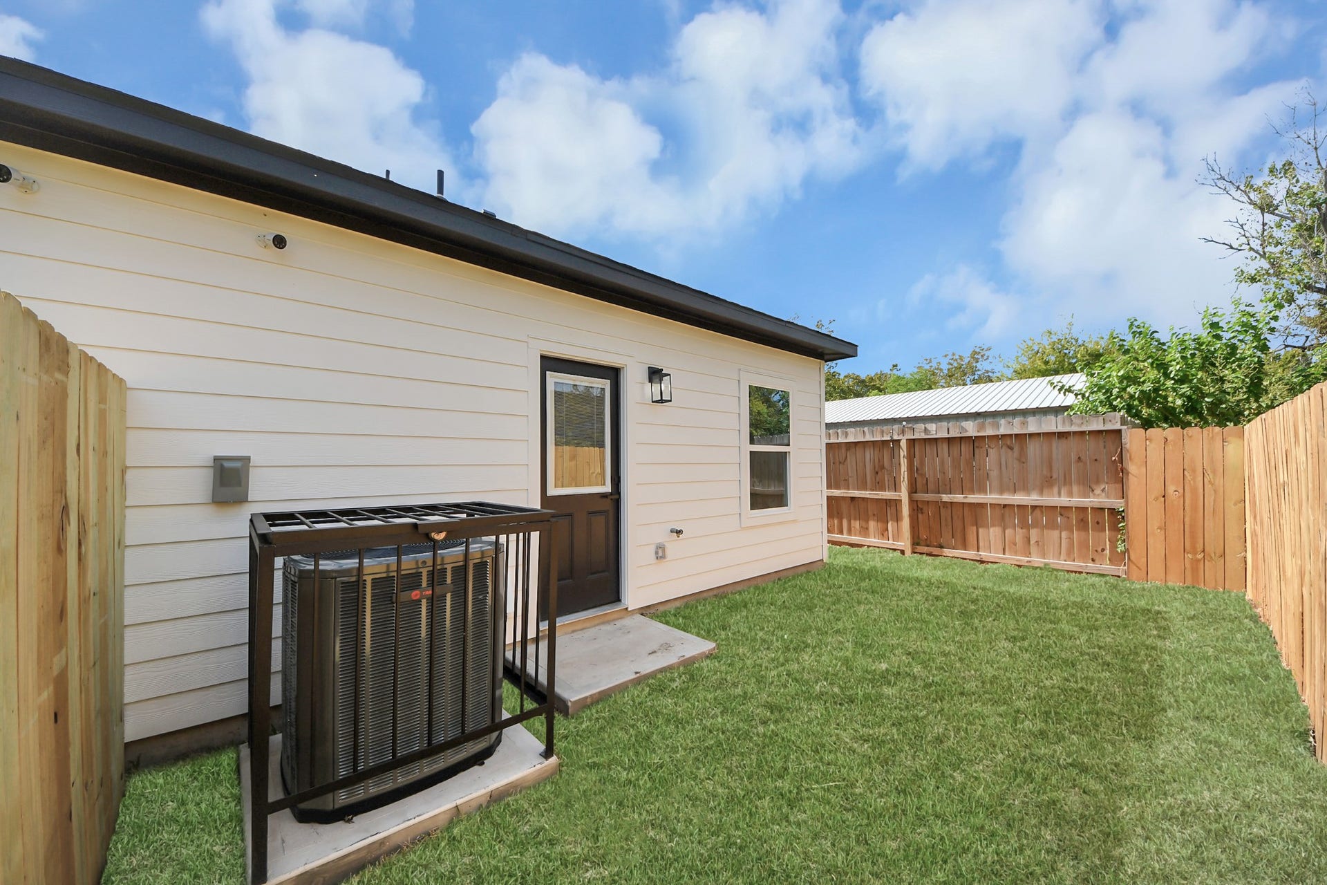 7801 King Street, Houston, TX 77028 Charming backyard with a neatly maintained lawn, privacy fence, and convenient backdoor access.