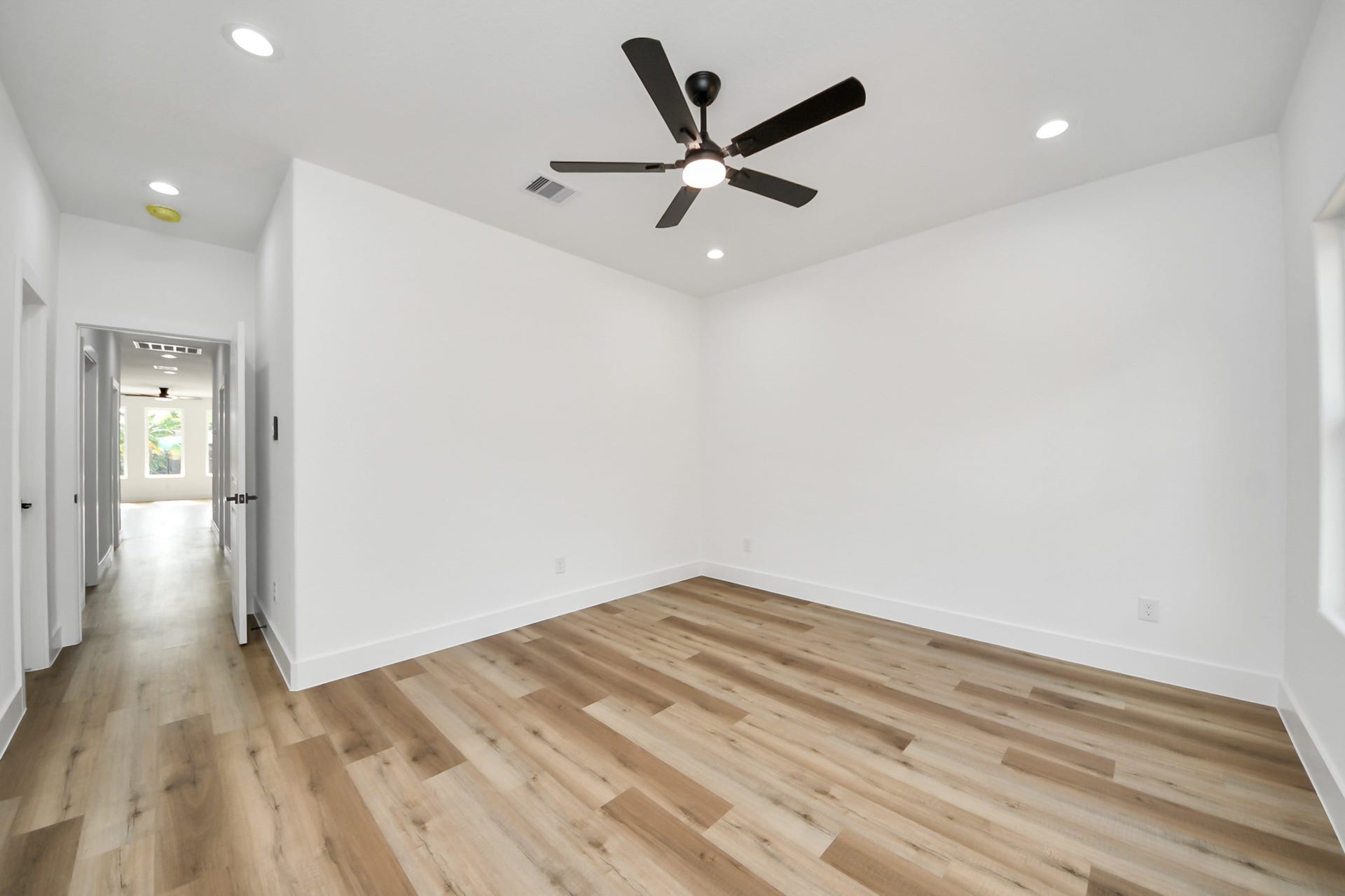 7801 King Street, Houston, TX 77028 Spacious and bright room with sleek hardwood floors and a modern ceiling fan, offering a versatile layout ideal for various uses.