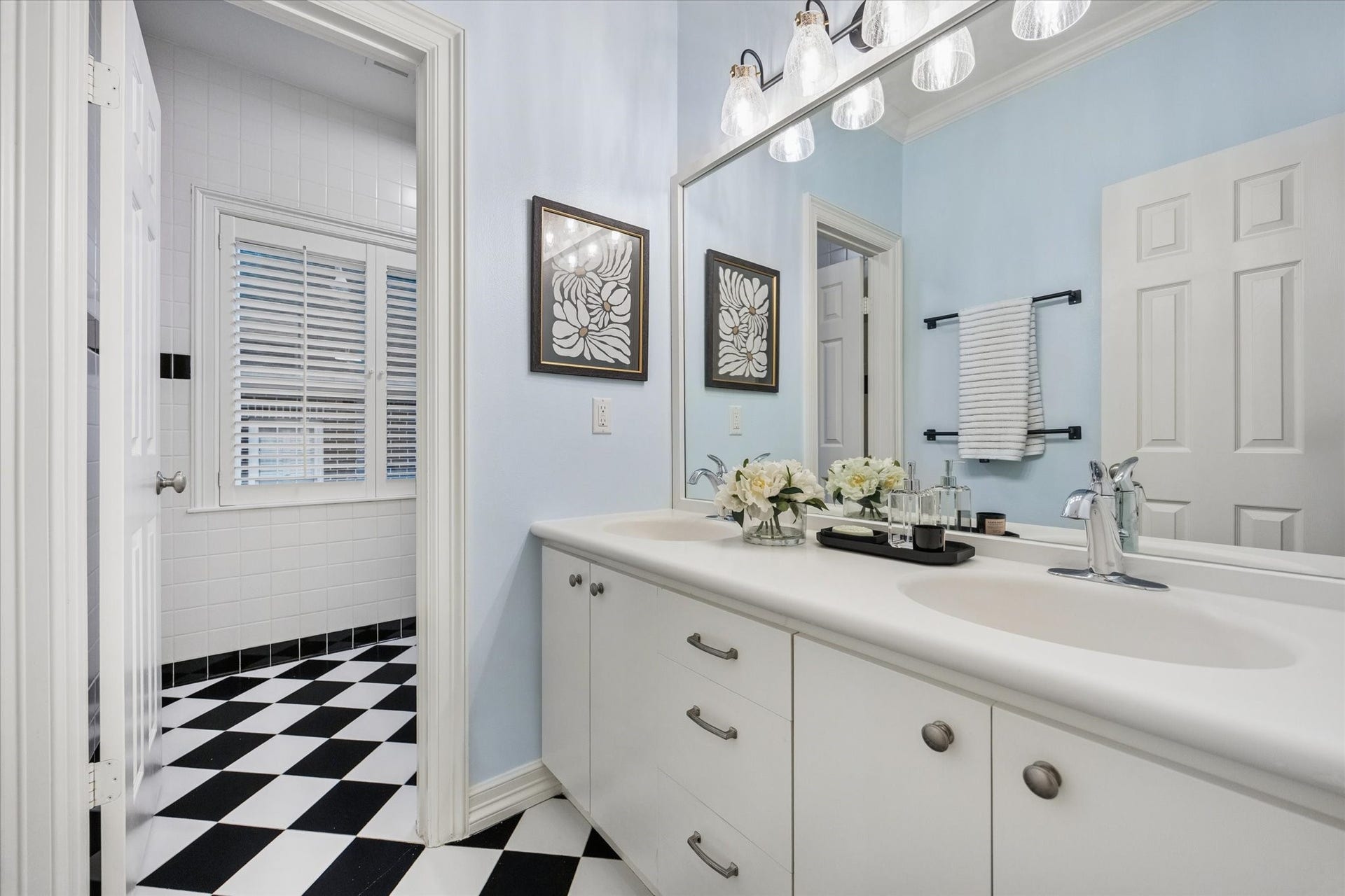 Secondary bathroom with dual sinks and a shower/tub combination, offering excellent functionality and generous vanity space.