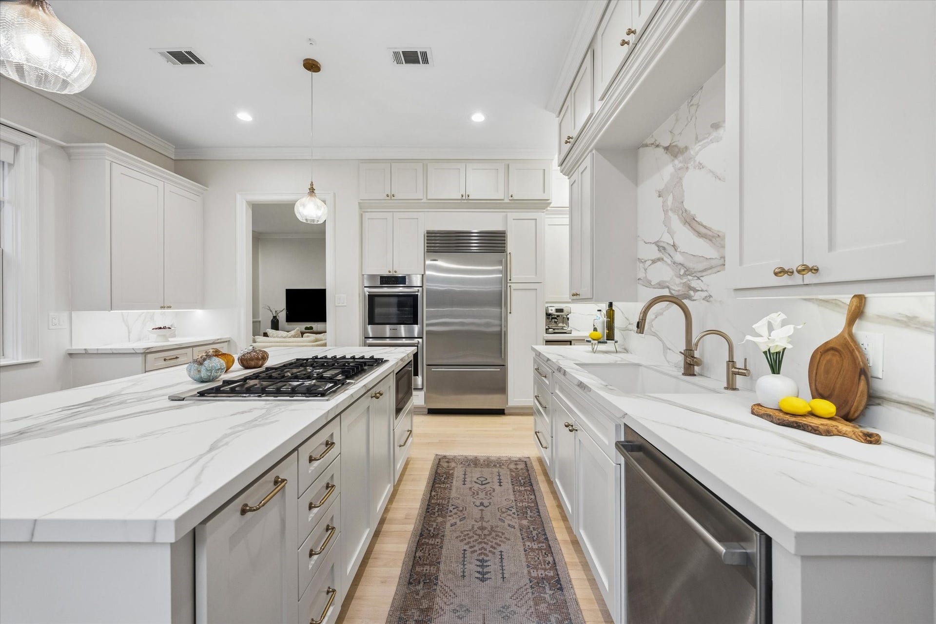 Another view of the beautifully updated kitchen highlights the expansive stone countertops, generous prep space and thoughtful layout designed for effortless everyday use.